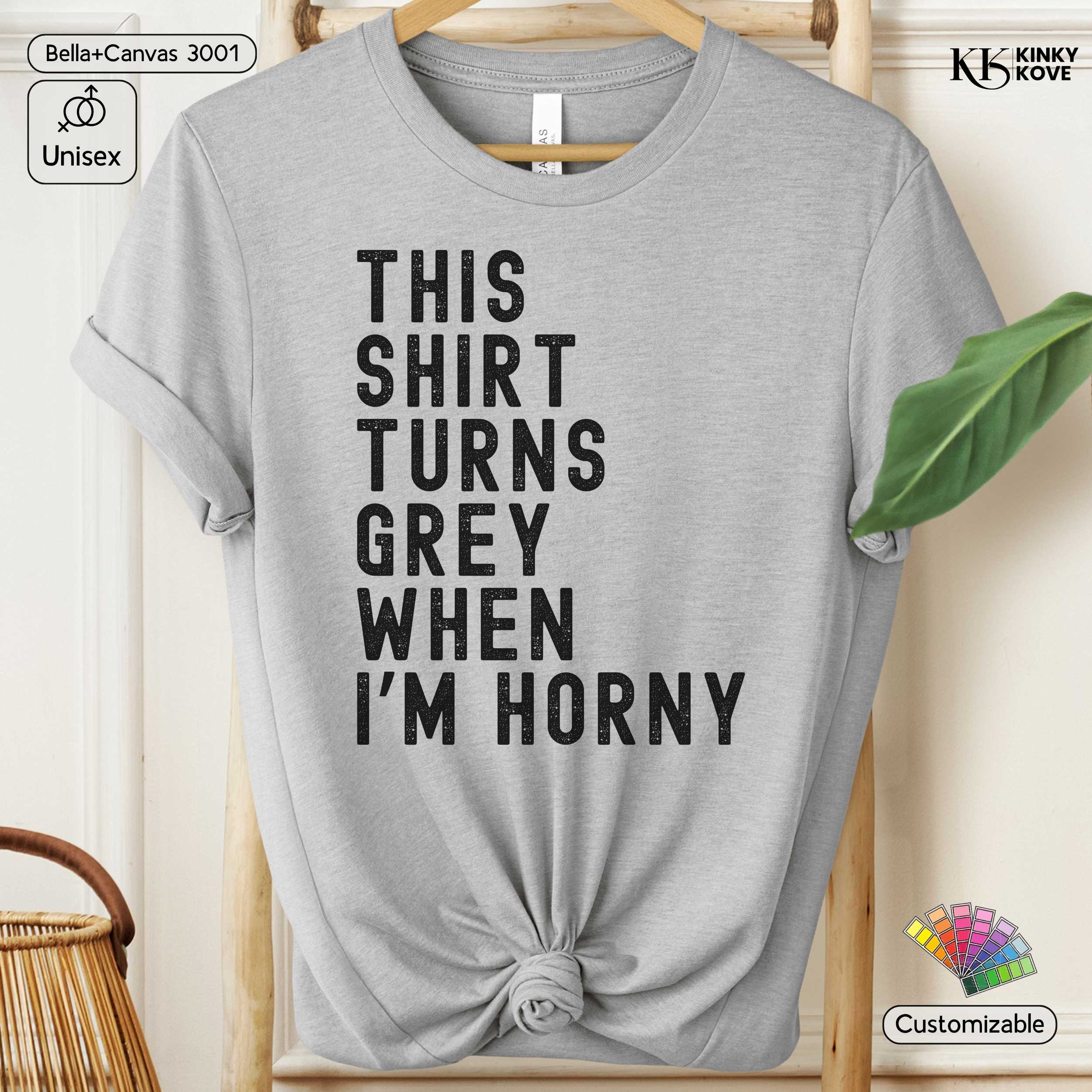 Gray t-shirt with humorous text on a hanger against a neutral background