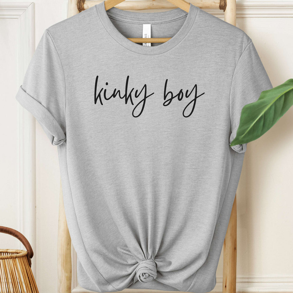 Gray t-shirt with 'kinky boy' text on a hanger against a neutral background