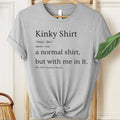 Gray t-shirt with humorous text design on a hanger.