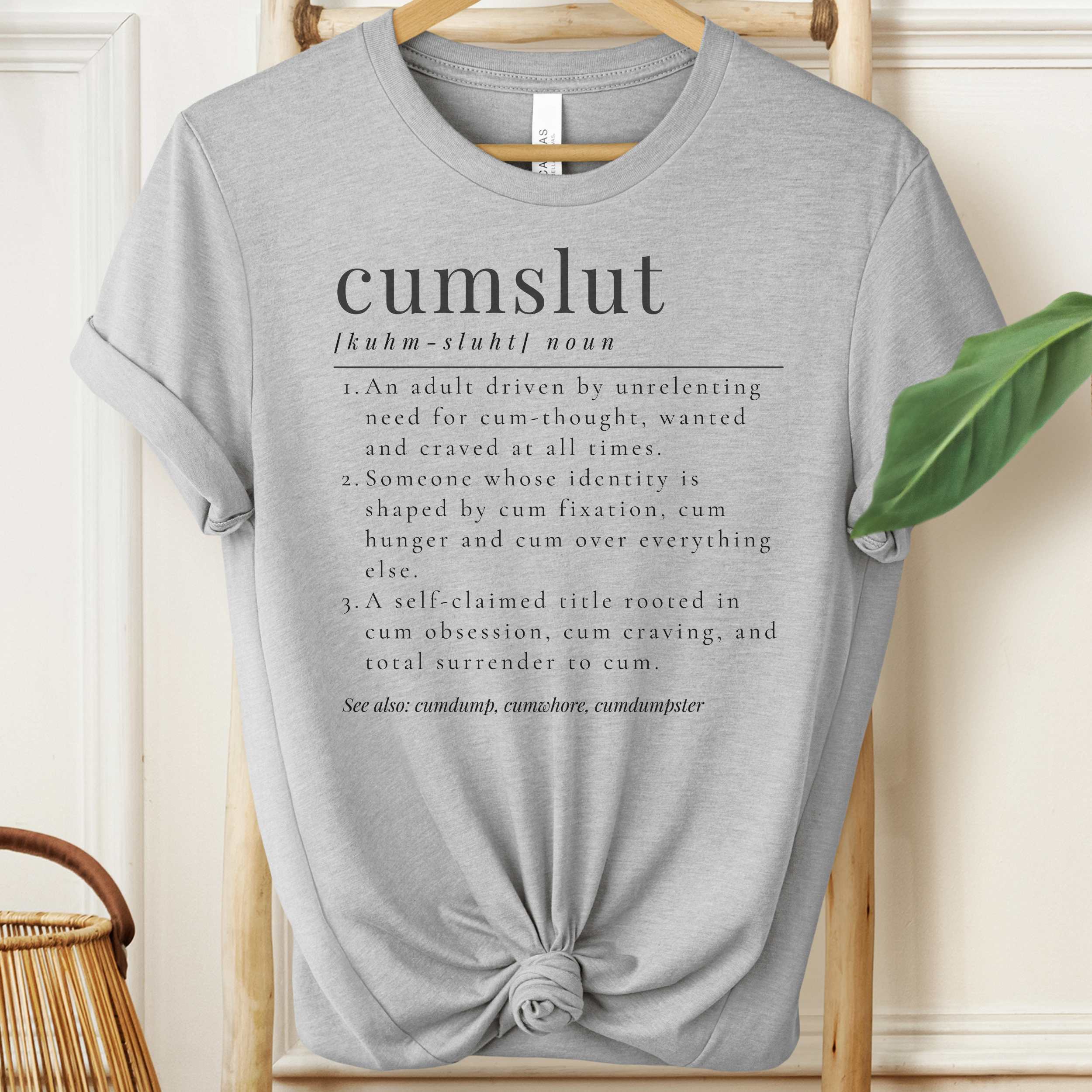 Gray t-shirt with text design on a wooden hanger