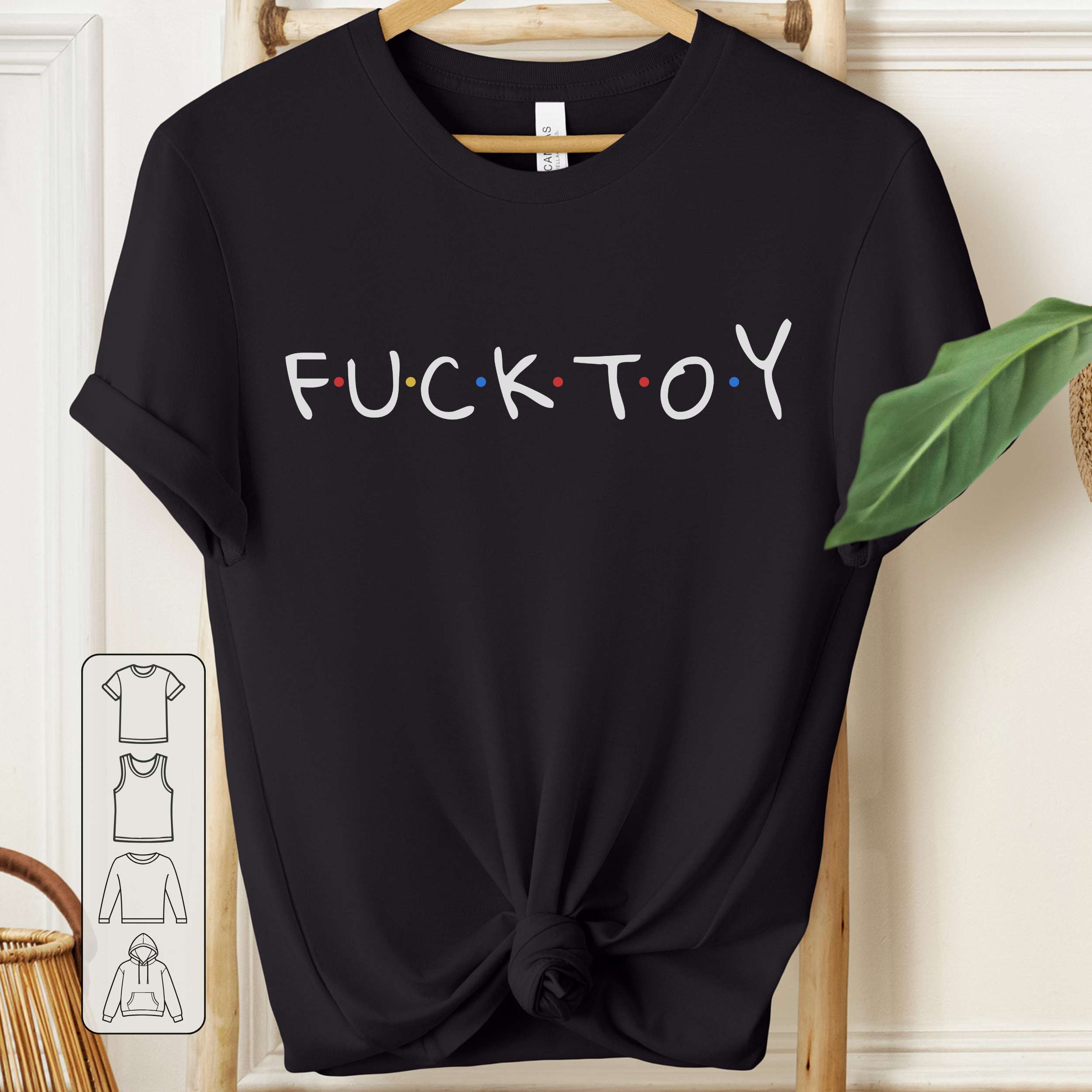 Black t-shirt with 'FUCKTOY' text on a wooden hanger.