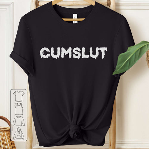 Black t-shirt with 'CUMSLUT' text on a hanger against a white wall.