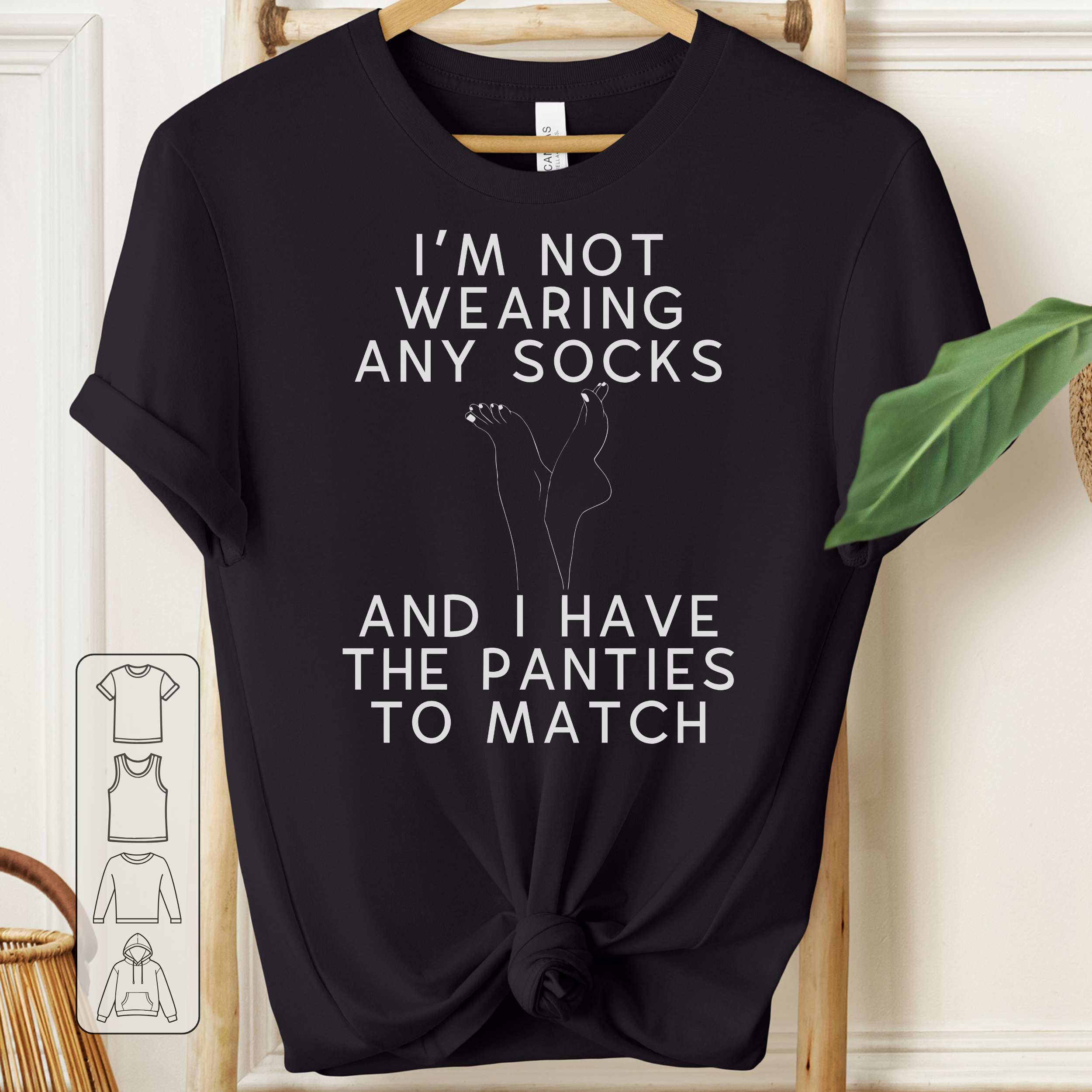 Black t-shirt with white text and graphic on a hanger against a neutral background