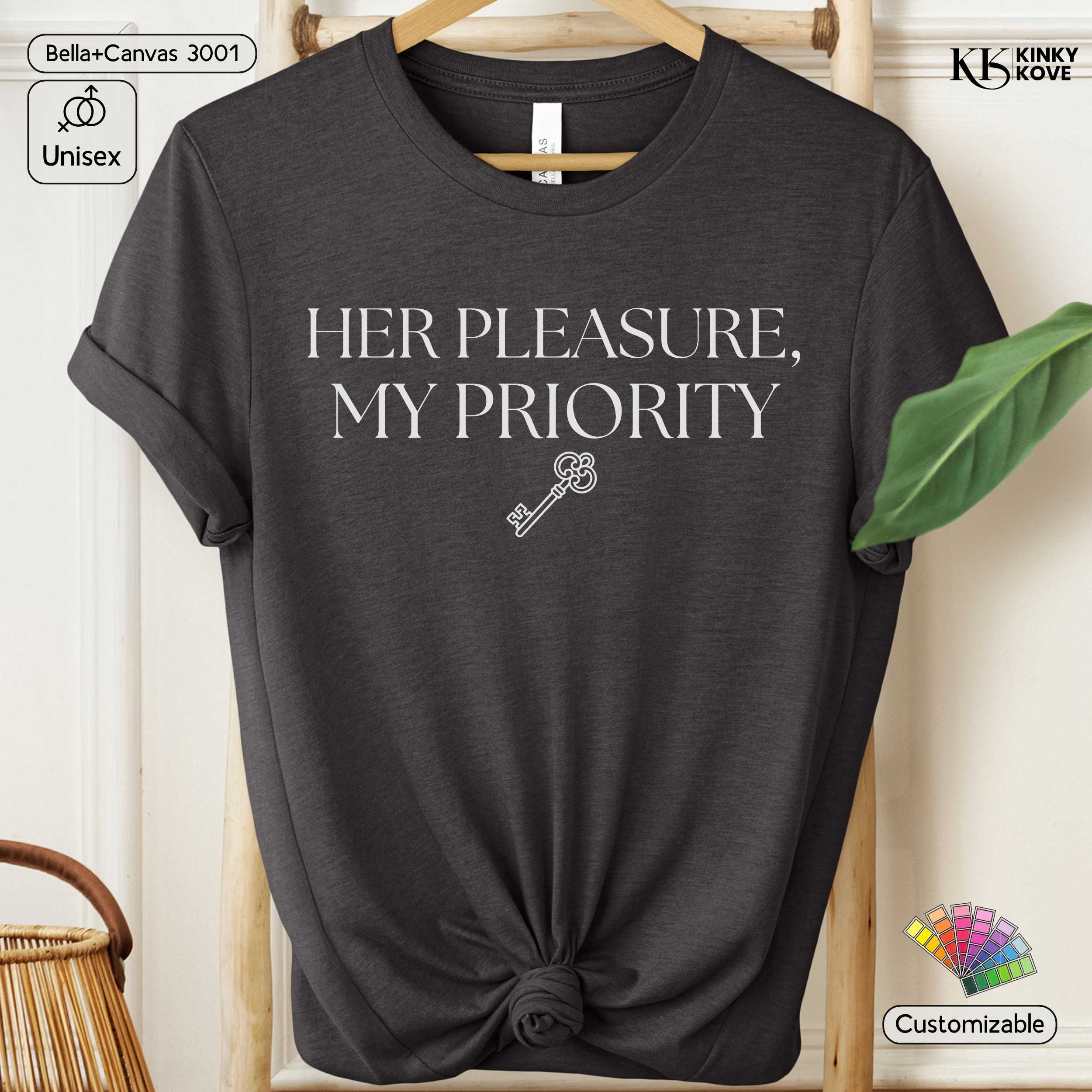 Dark gray t-shirt with 'Her Pleasure, My Priority' text and key graphic on a hanger.