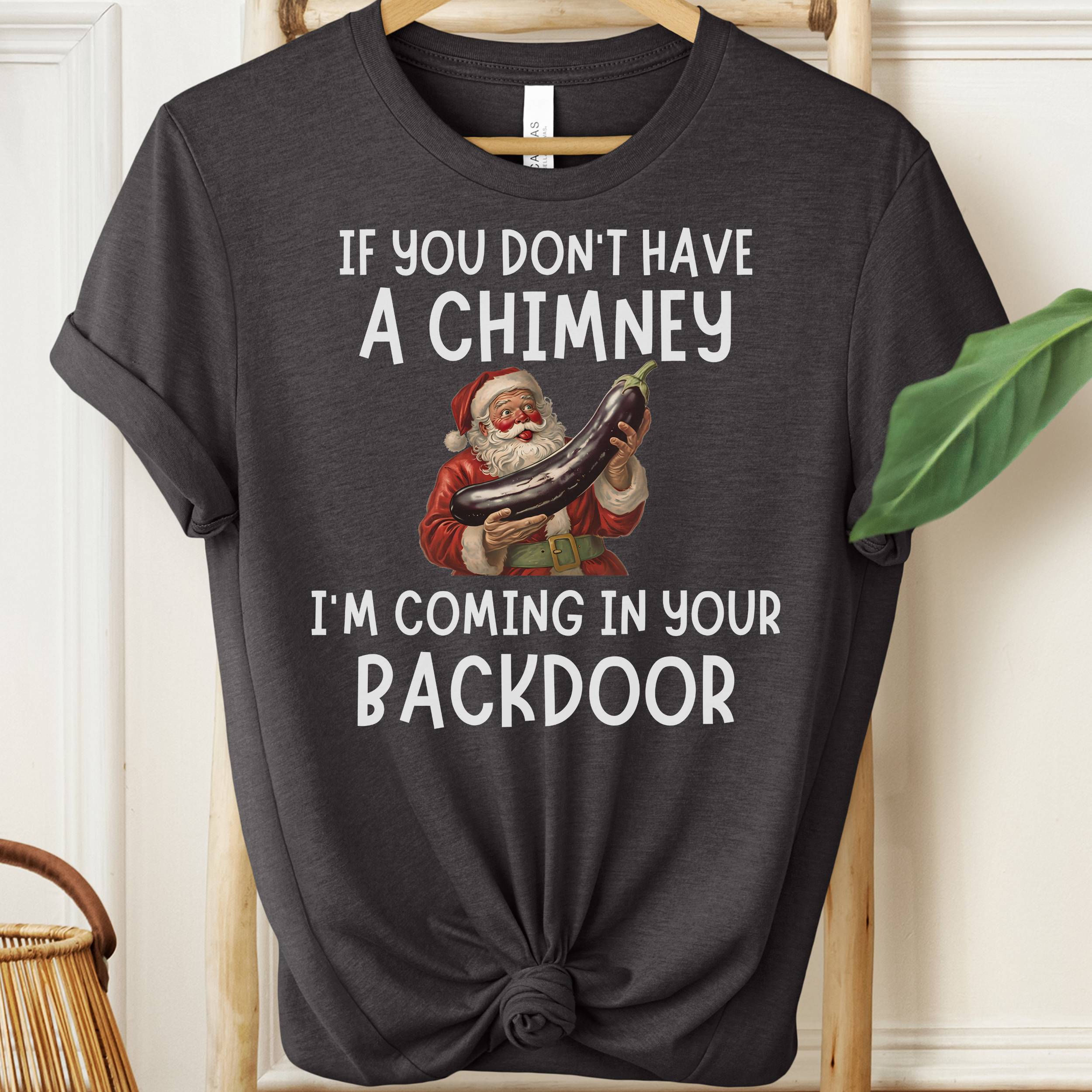 Black t-shirt with Santa Claus graphic and humorous text on a hanger.