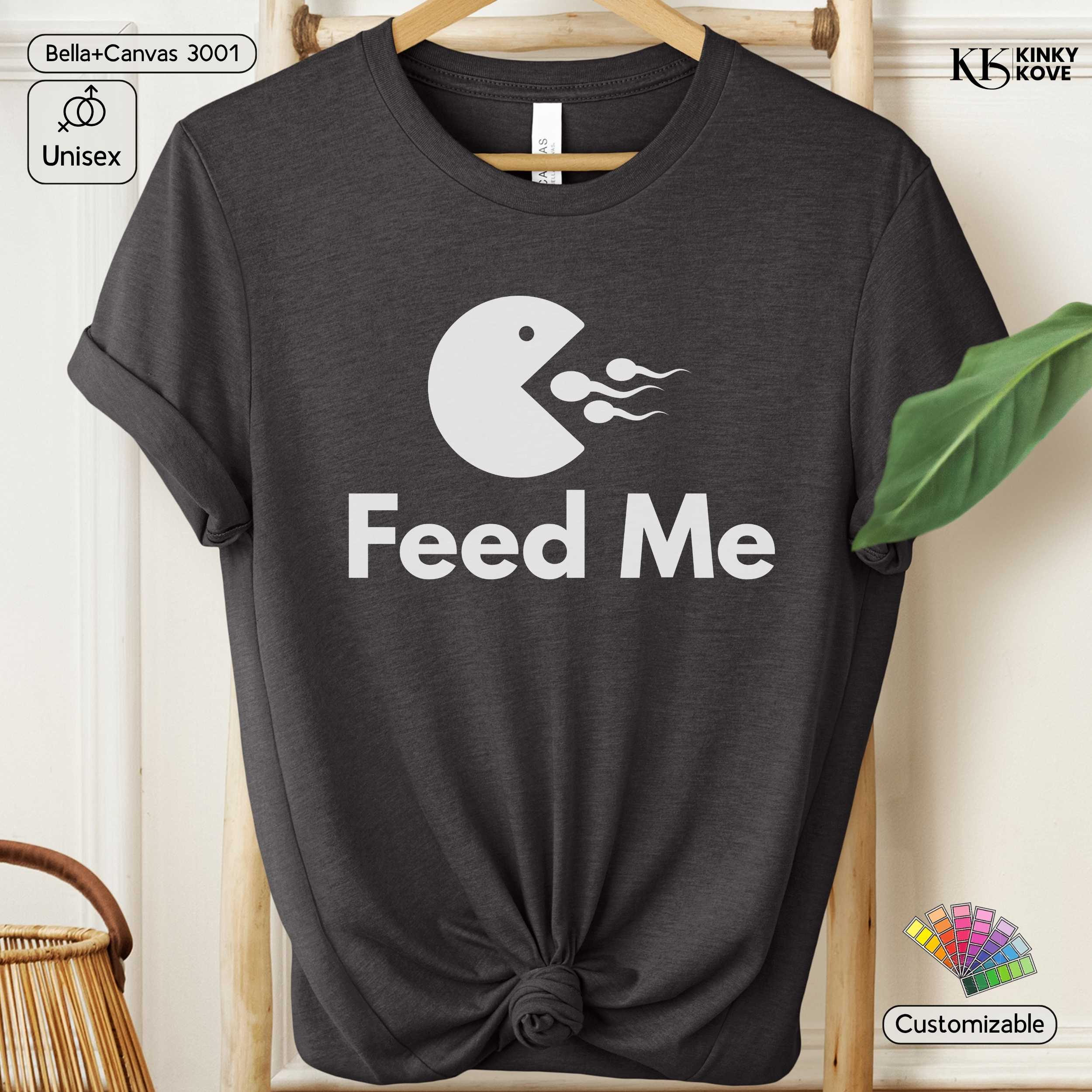 Dark gray t-shirt with 'Feed Me' graphic design on a hanger against a white background.