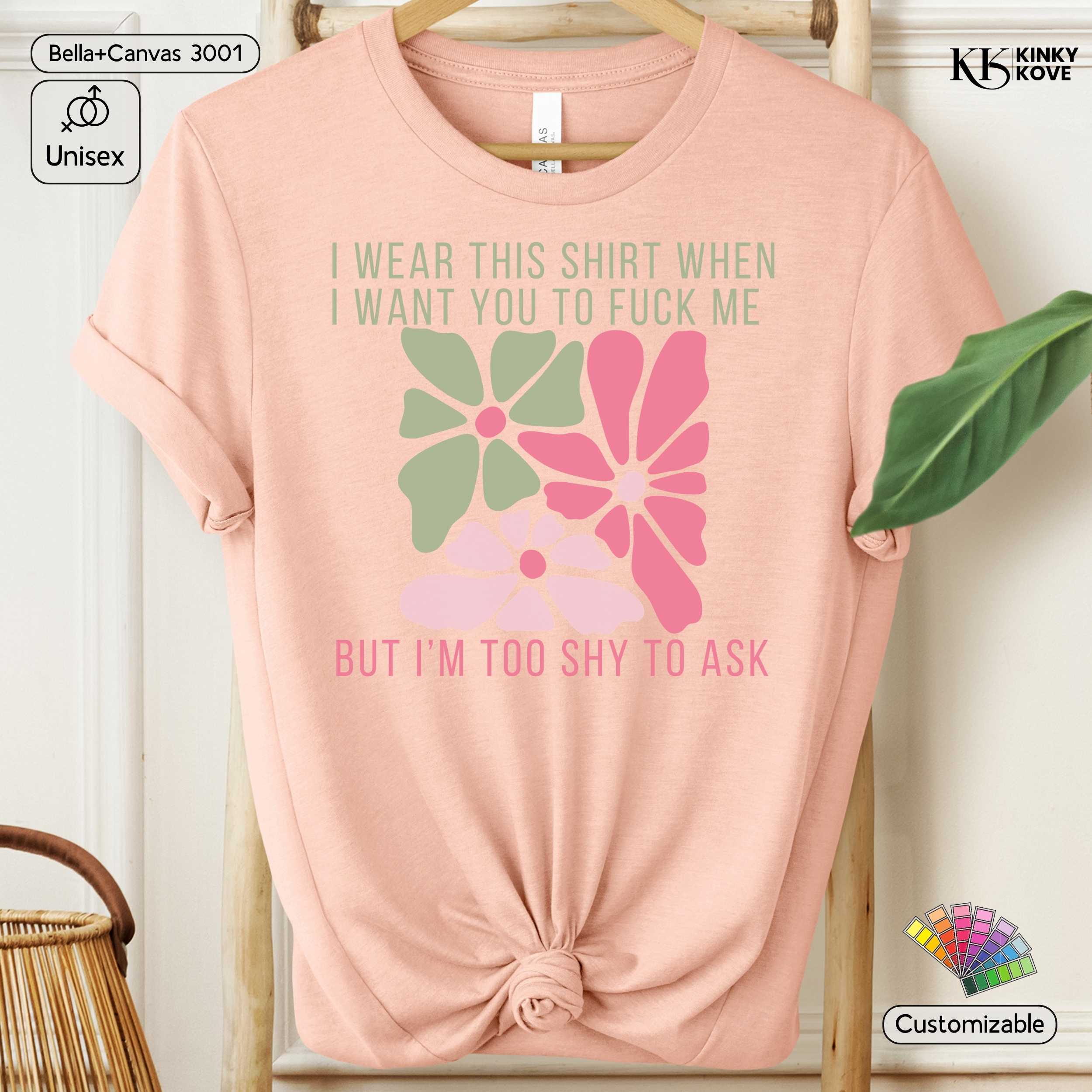 Pink t-shirt with floral design and text on a hanger