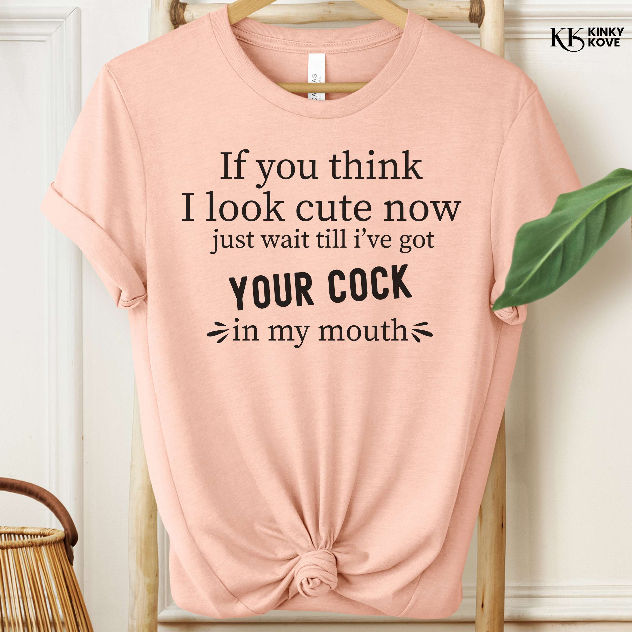Pink t-shirt with black text on a hanger, brand 'Kinky Kove' visible