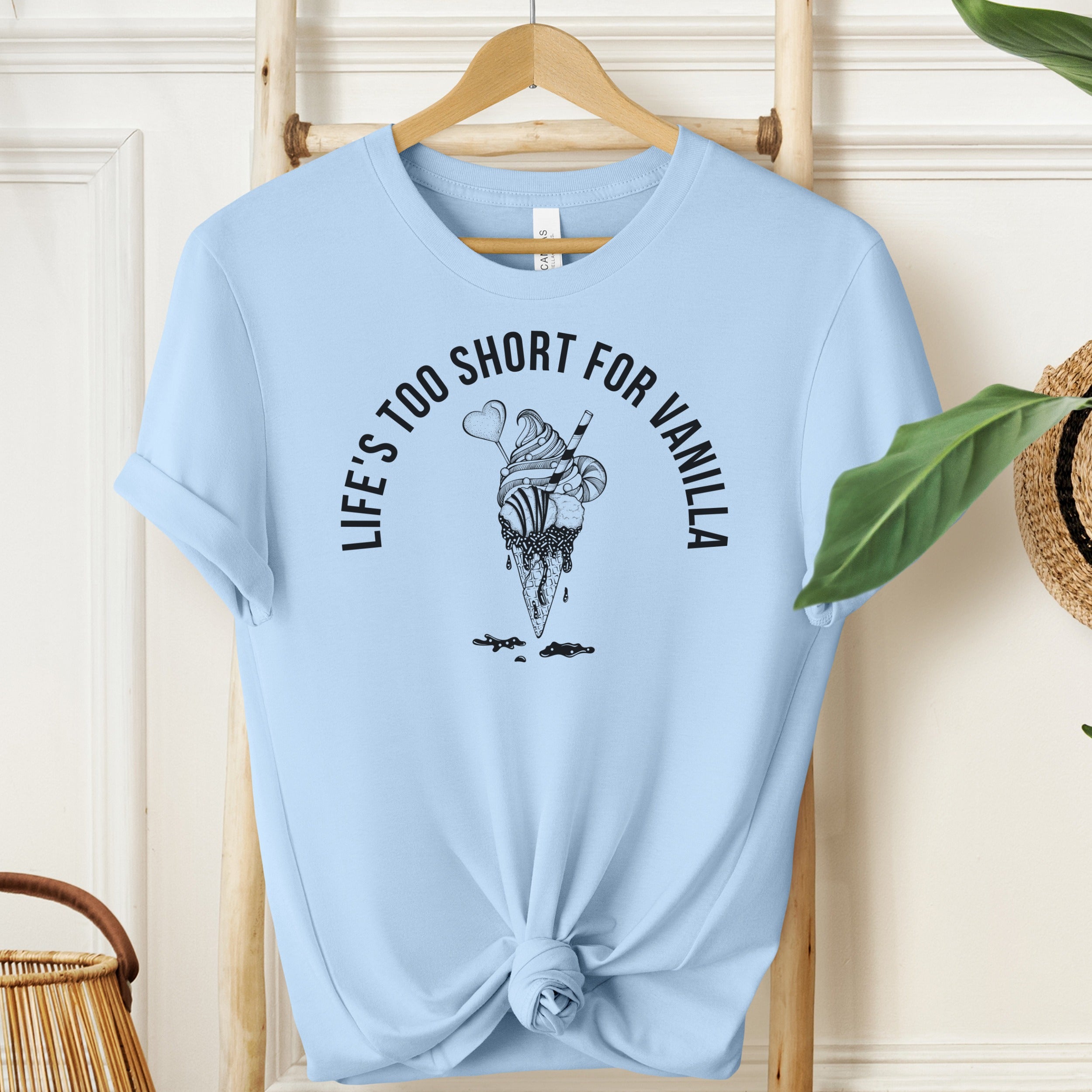Light blue t-shirt with ice cream graphic and text on a wooden hanger.