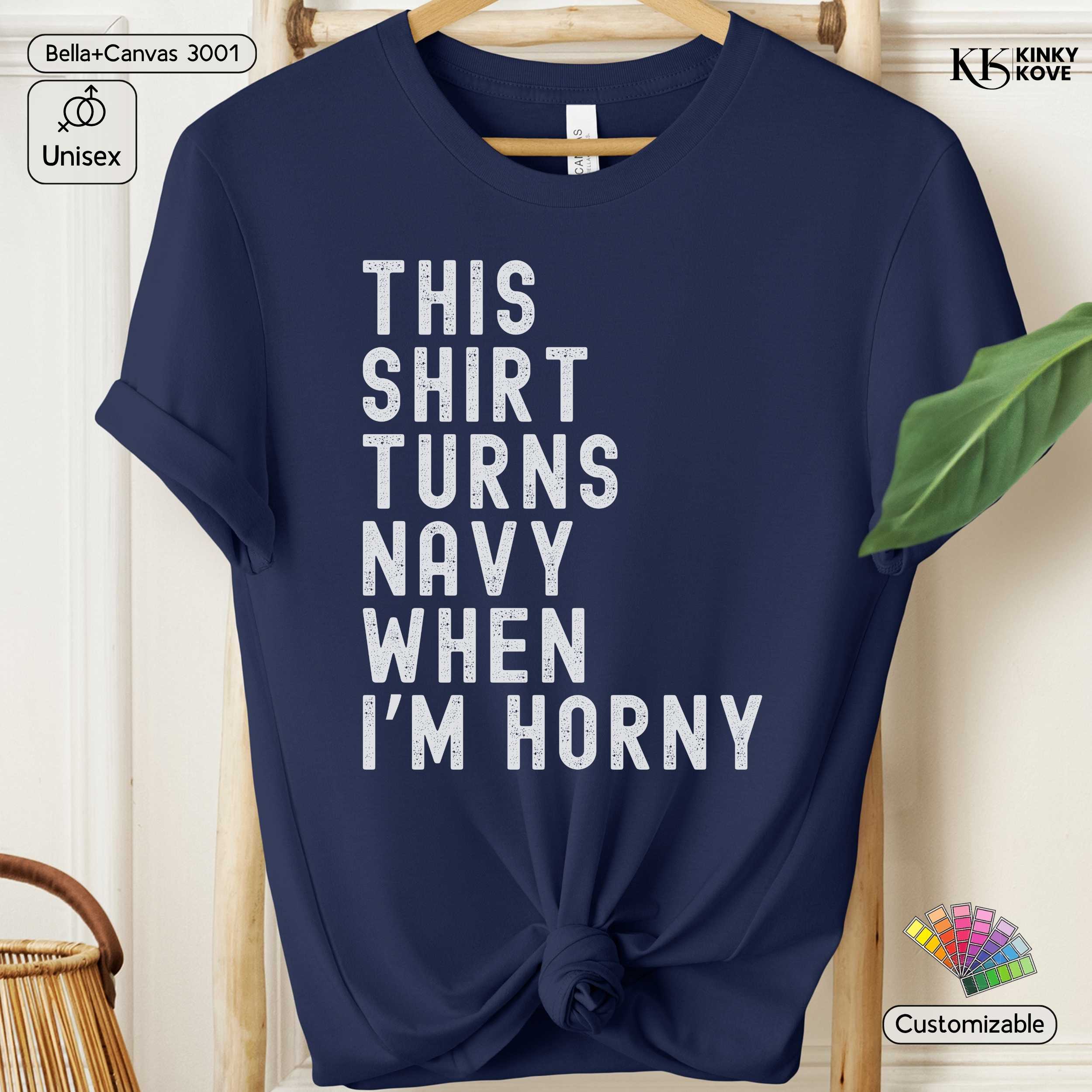 Navy blue t-shirt with humorous text on a hanger against a neutral background