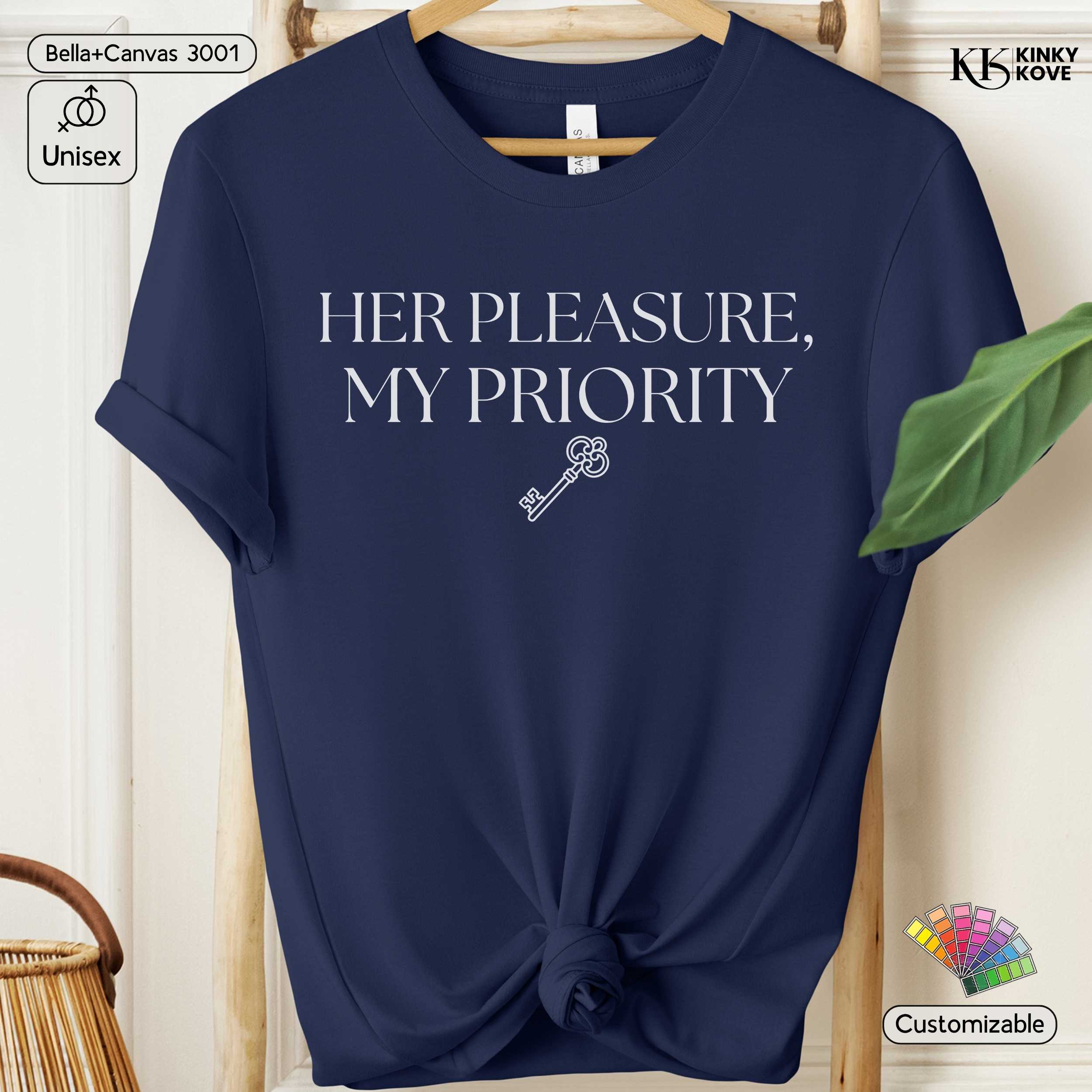 Navy blue t-shirt with 'HER PLEASURE, MY PRIORITY' text and key graphic on a hanger.