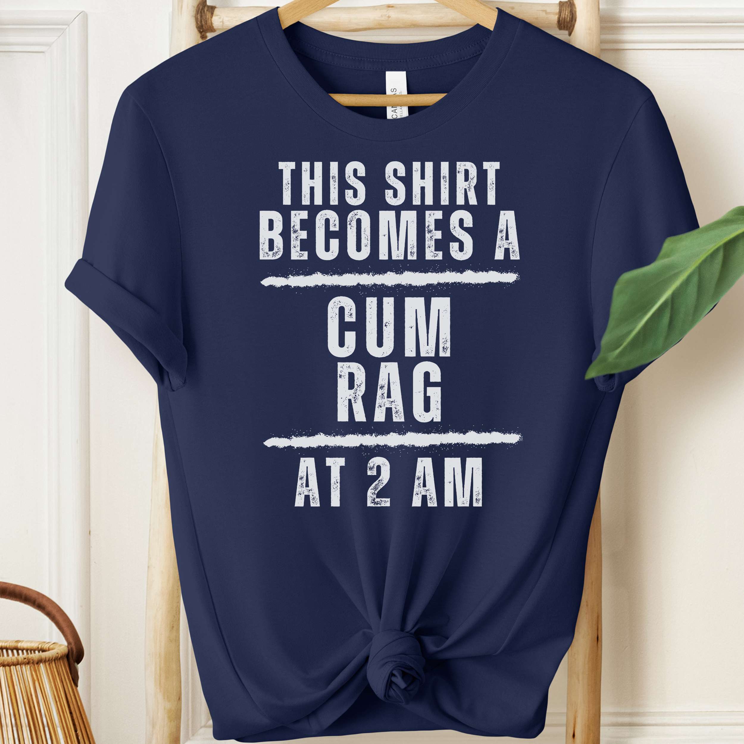 Navy blue t-shirt with white text on a hanger against a neutral background