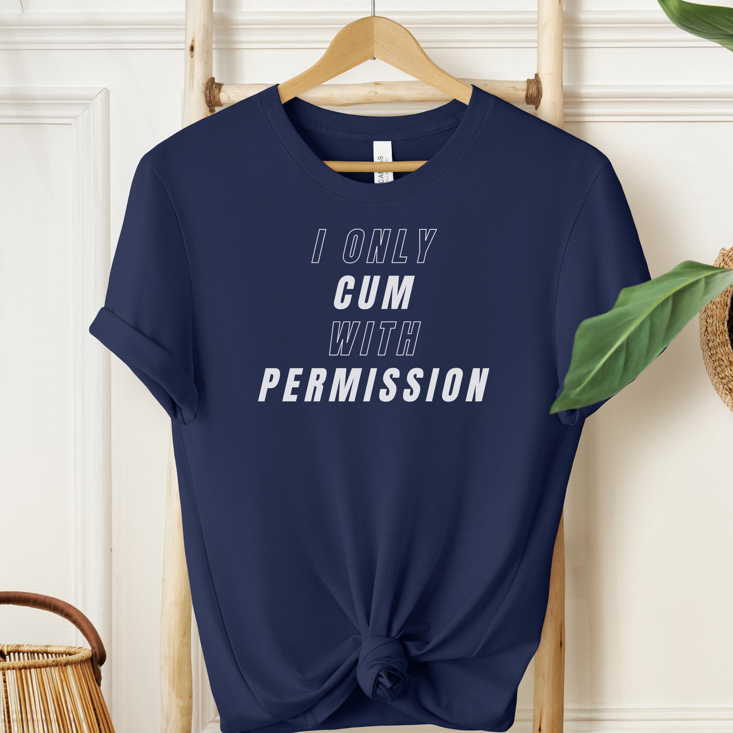 Navy blue t-shirt with white text 'I ONLY CUM WITH PERMISSION' on a wooden hanger.