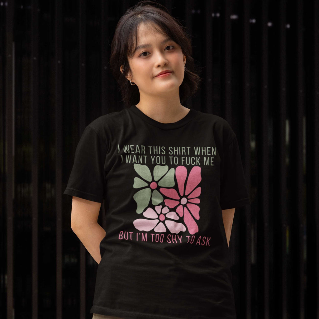 Person wearing a black t-shirt with graphic design and text against a dark background