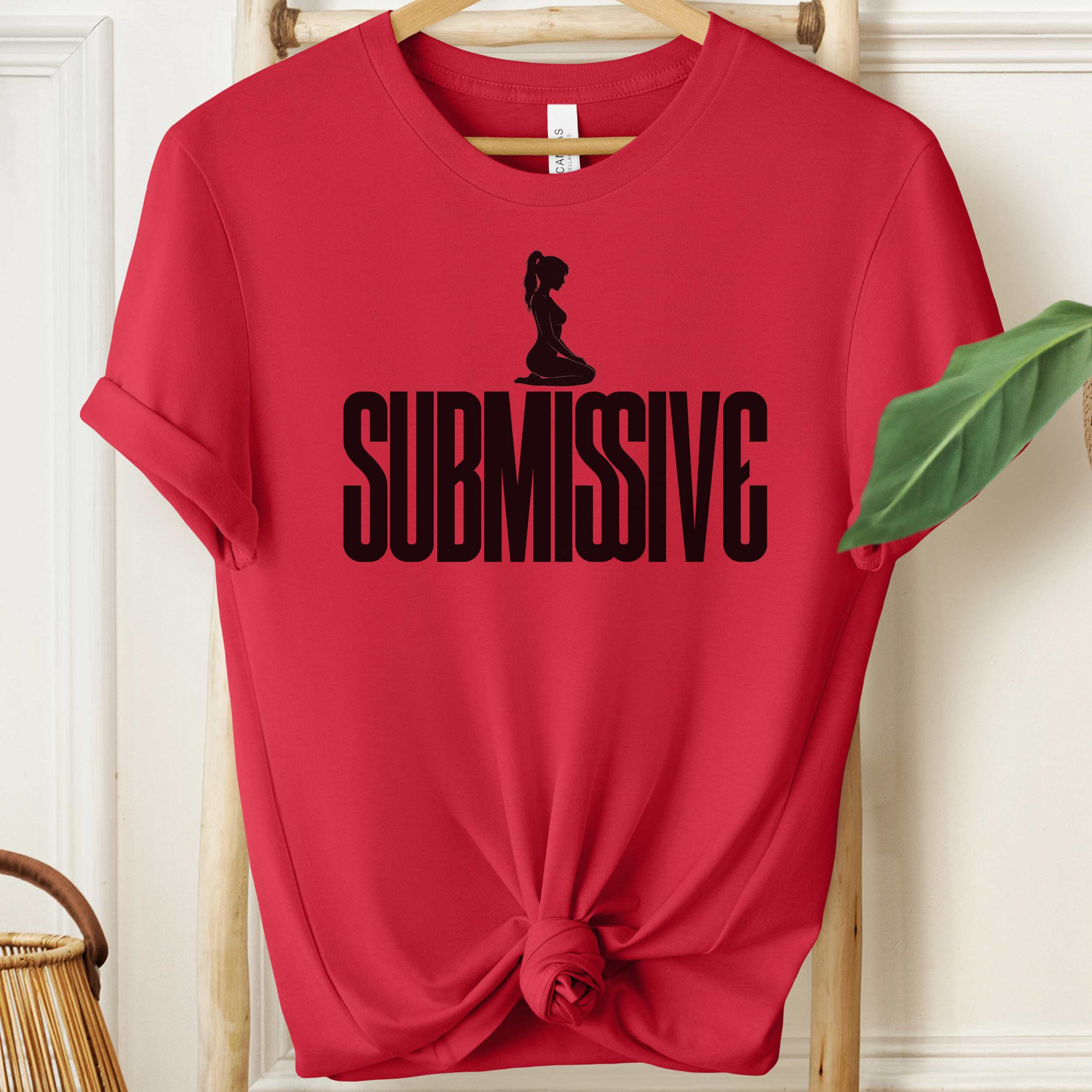 Red t-shirt with 'SUBMISSIVE' text and silhouette graphic on a hanger.