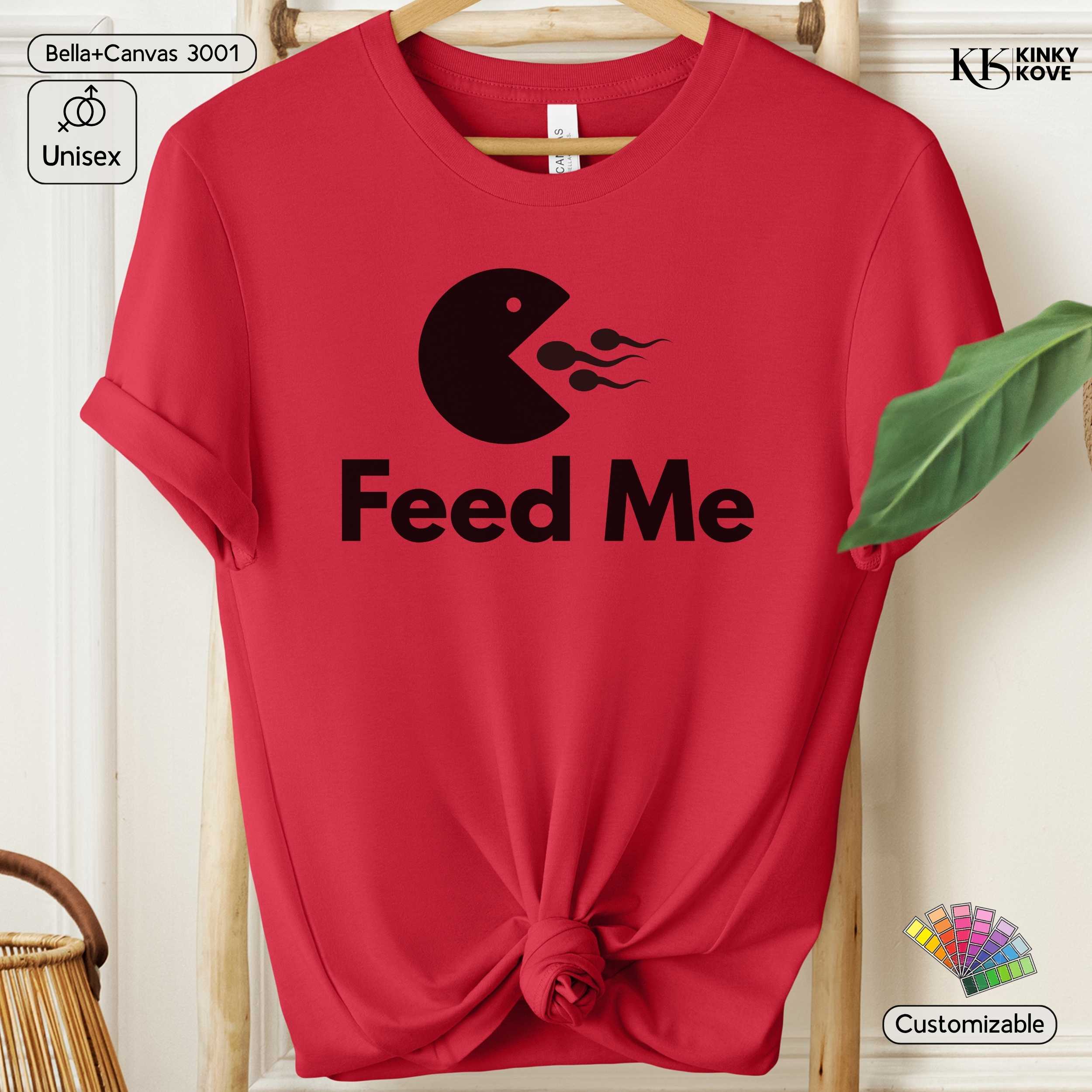 Red t-shirt with black graphic and 'Feed Me' text on a hanger