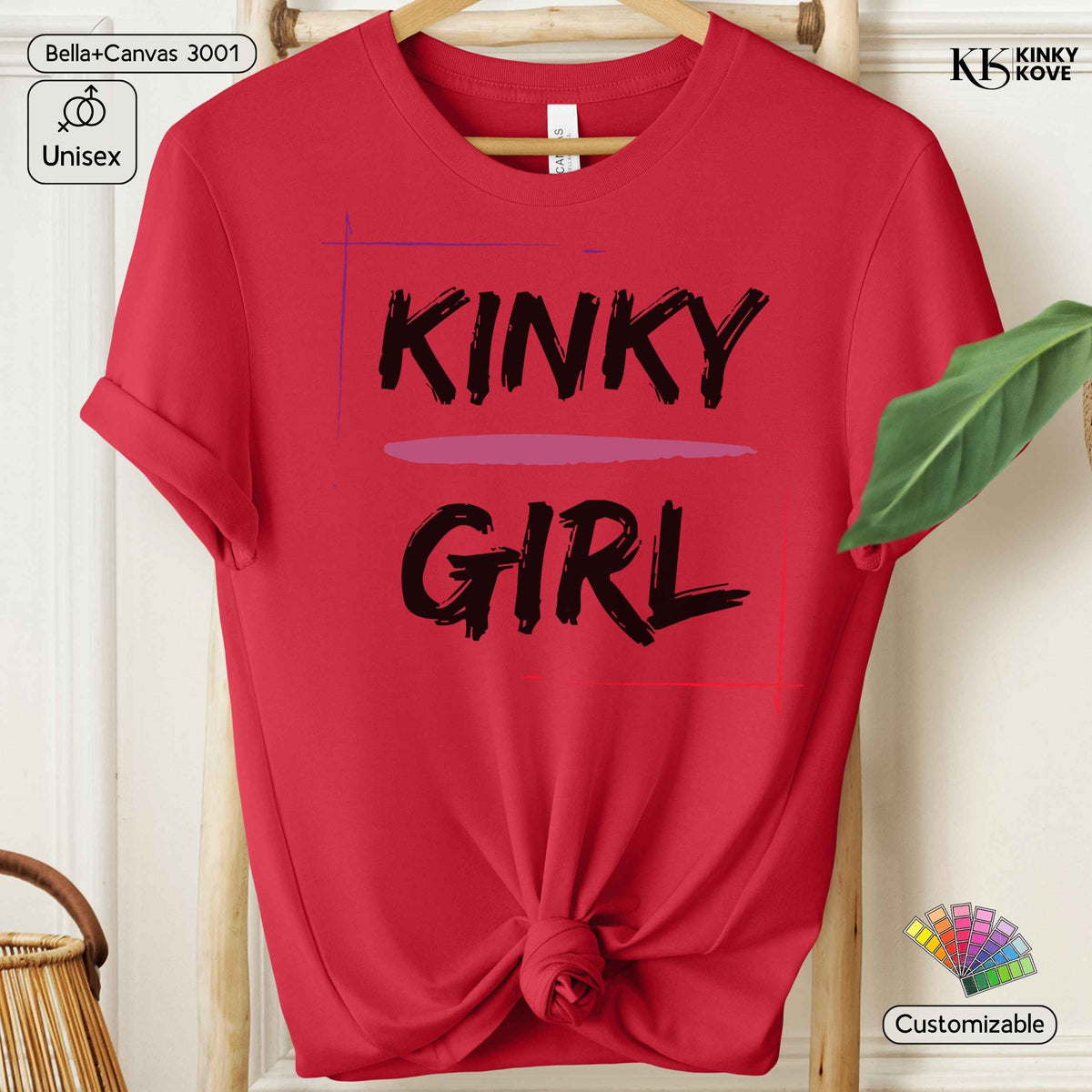 A red short-sleeve t-shirt hanging on a wooden hanger, styled with a knot at the bottom hem. The shirt features the words 'KINKY GIRL' printed in black brush-style lettering with a light purple horizontal brushstroke accent between the words.