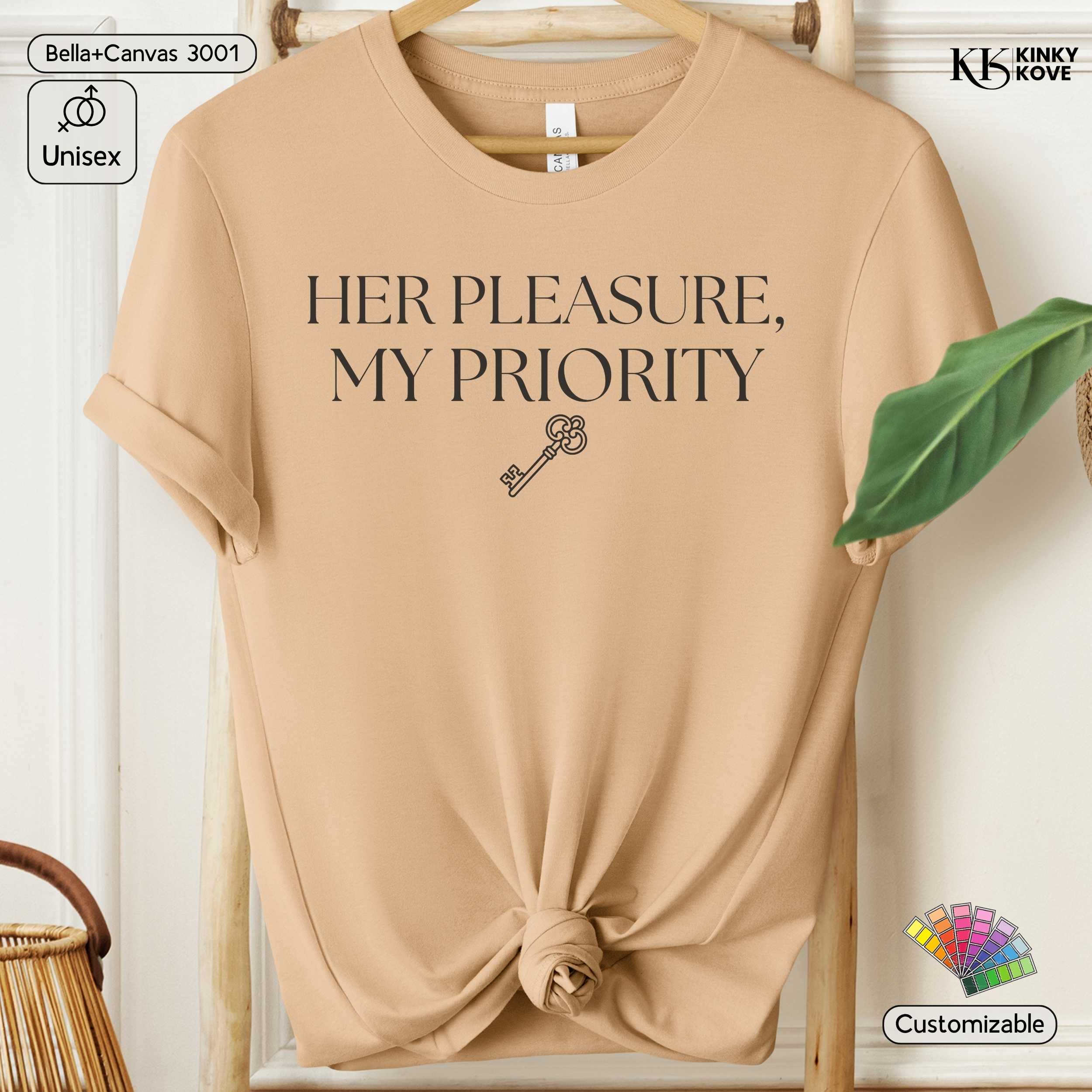 Beige t-shirt with 'HER PLEASURE, MY PRIORITY' text and key graphic on a hanger.
