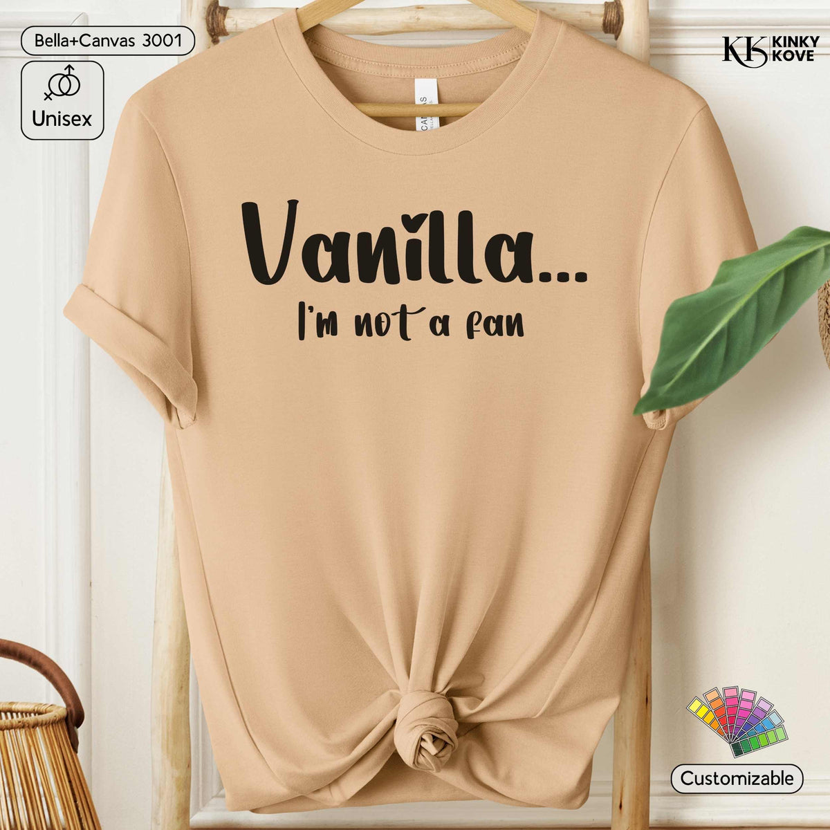 A beige short-sleeve t-shirt on a wooden hanger with rolled sleeves and a knotted hem, featuring the black printed text 'Vanilla.