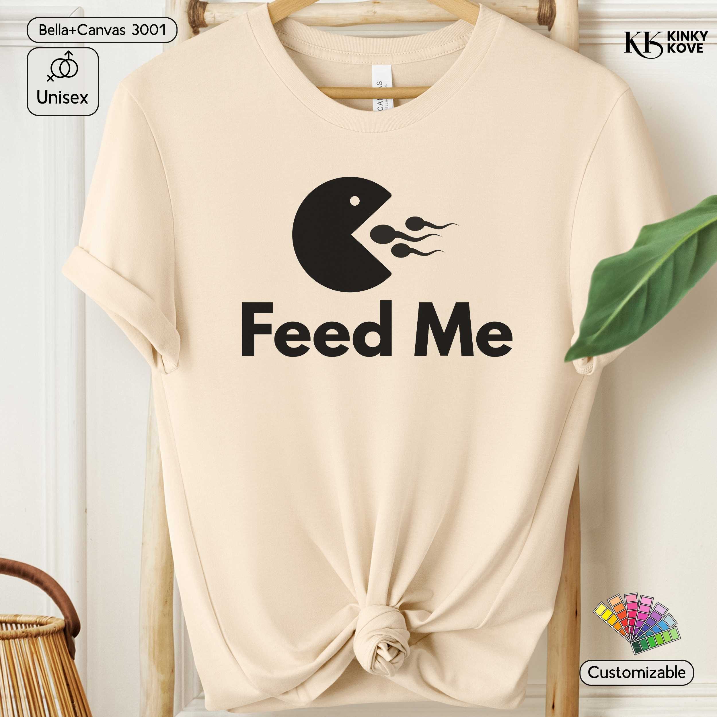 Beige t-shirt with 'Feed Me' graphic design on a hanger
