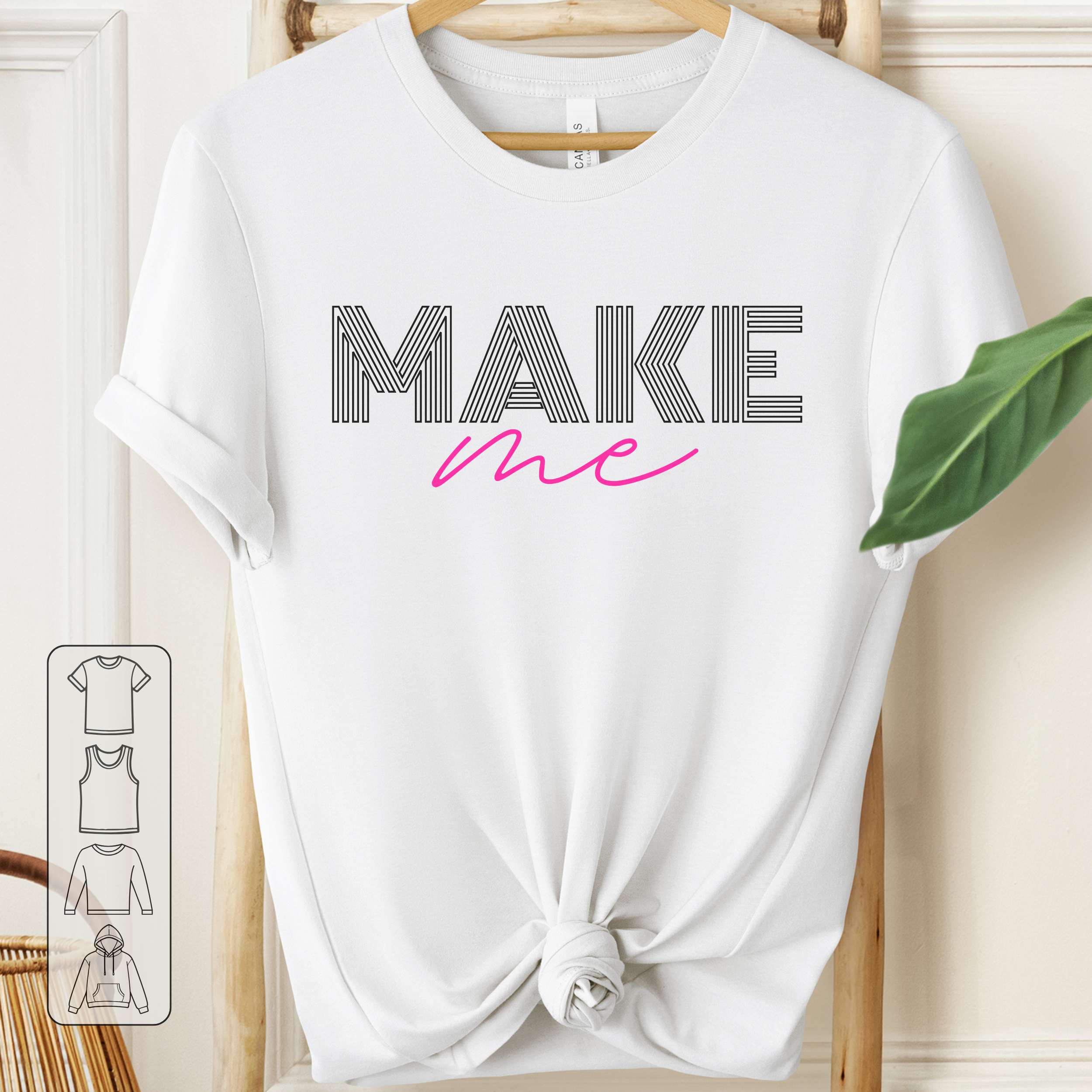 White t-shirt with 'MAKE me' text on a wooden hanger.