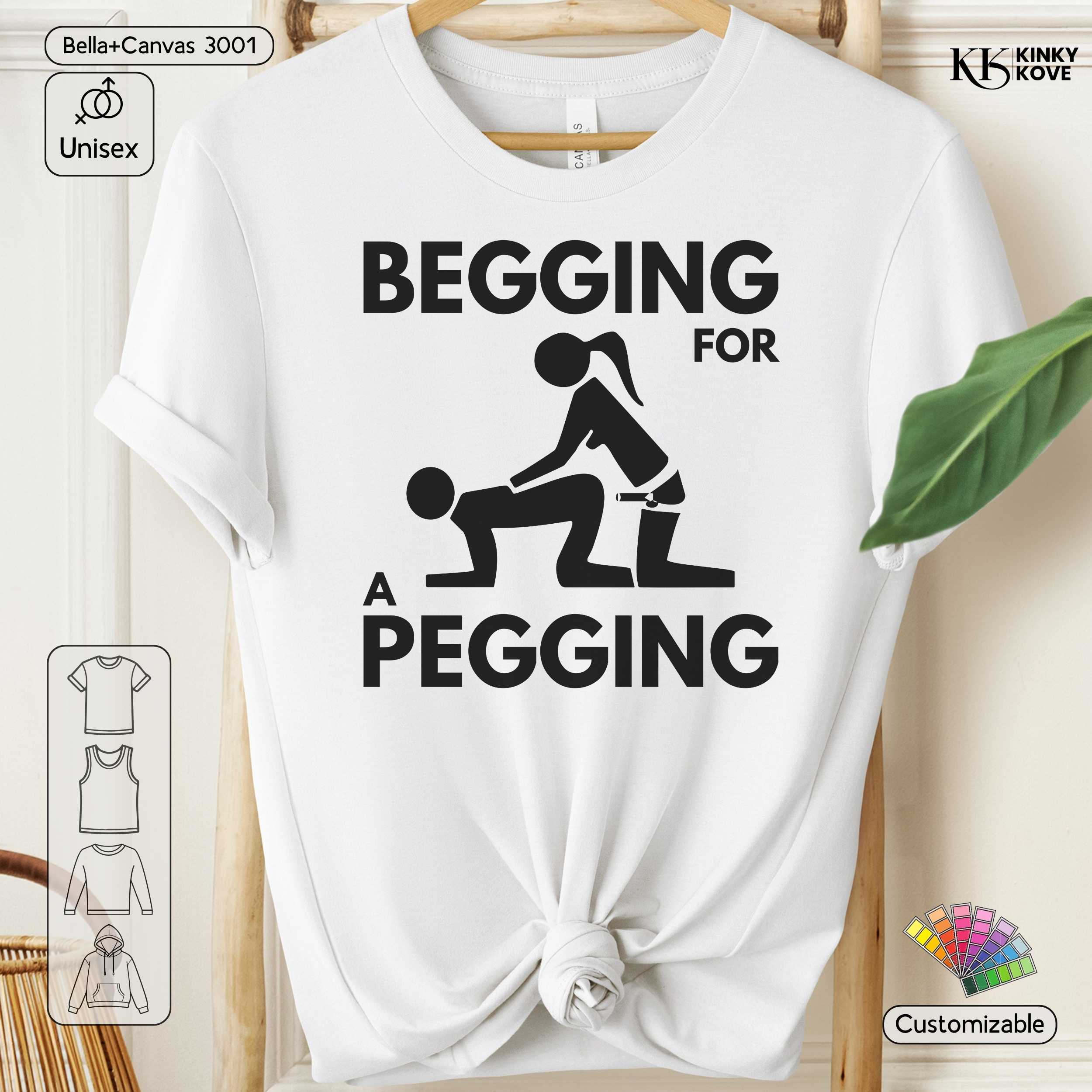 White t-shirt with graphic design and text 'Begging for a Pegging' on a wooden hanger.
