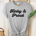 Gray t-shirt with 'Kinky & Proud' text on a hanger.