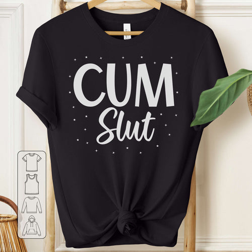 Black t-shirt with 'Cum Slut' text on a hanger against a white wall.