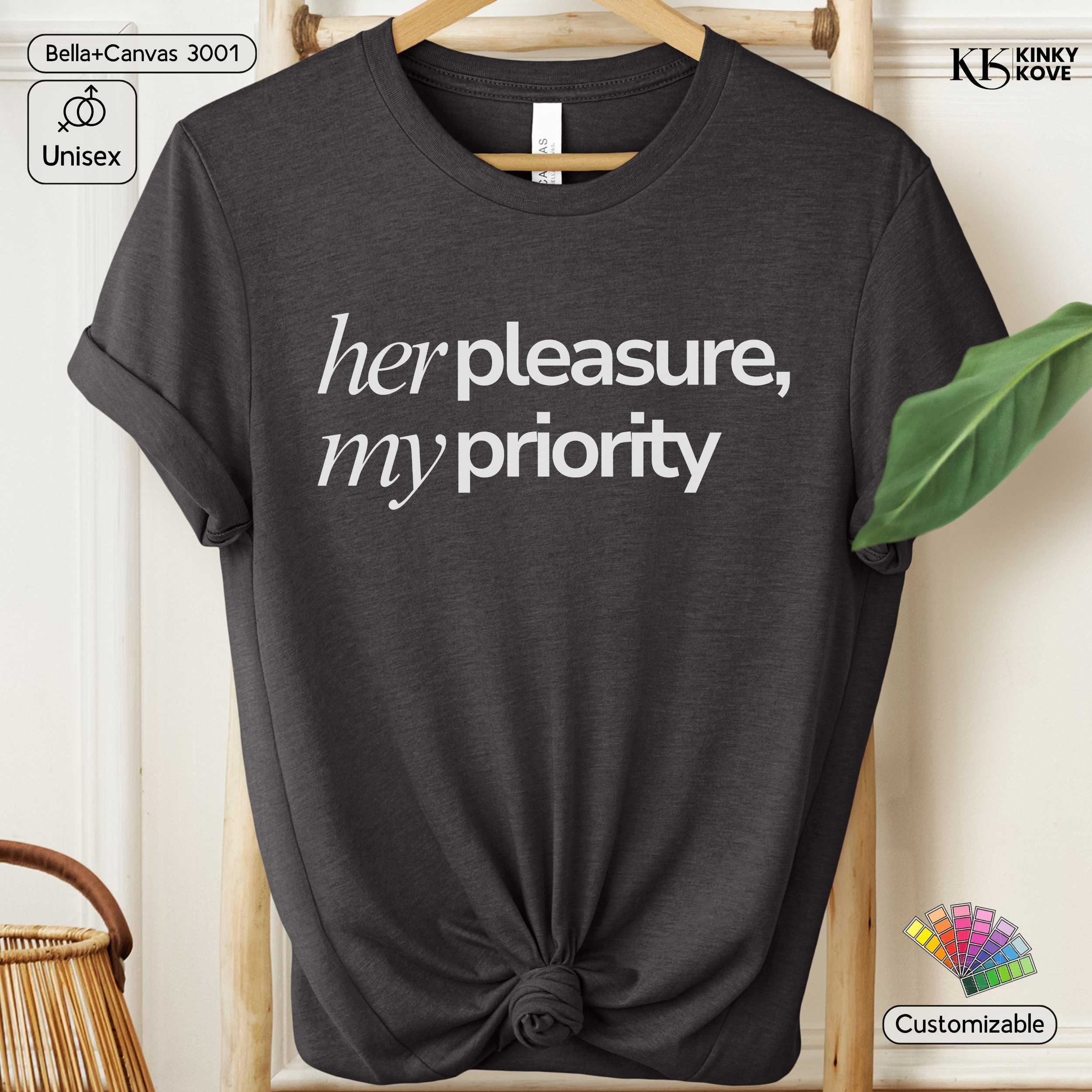 Black t-shirt with 'her pleasure, my priority' text on a hanger.