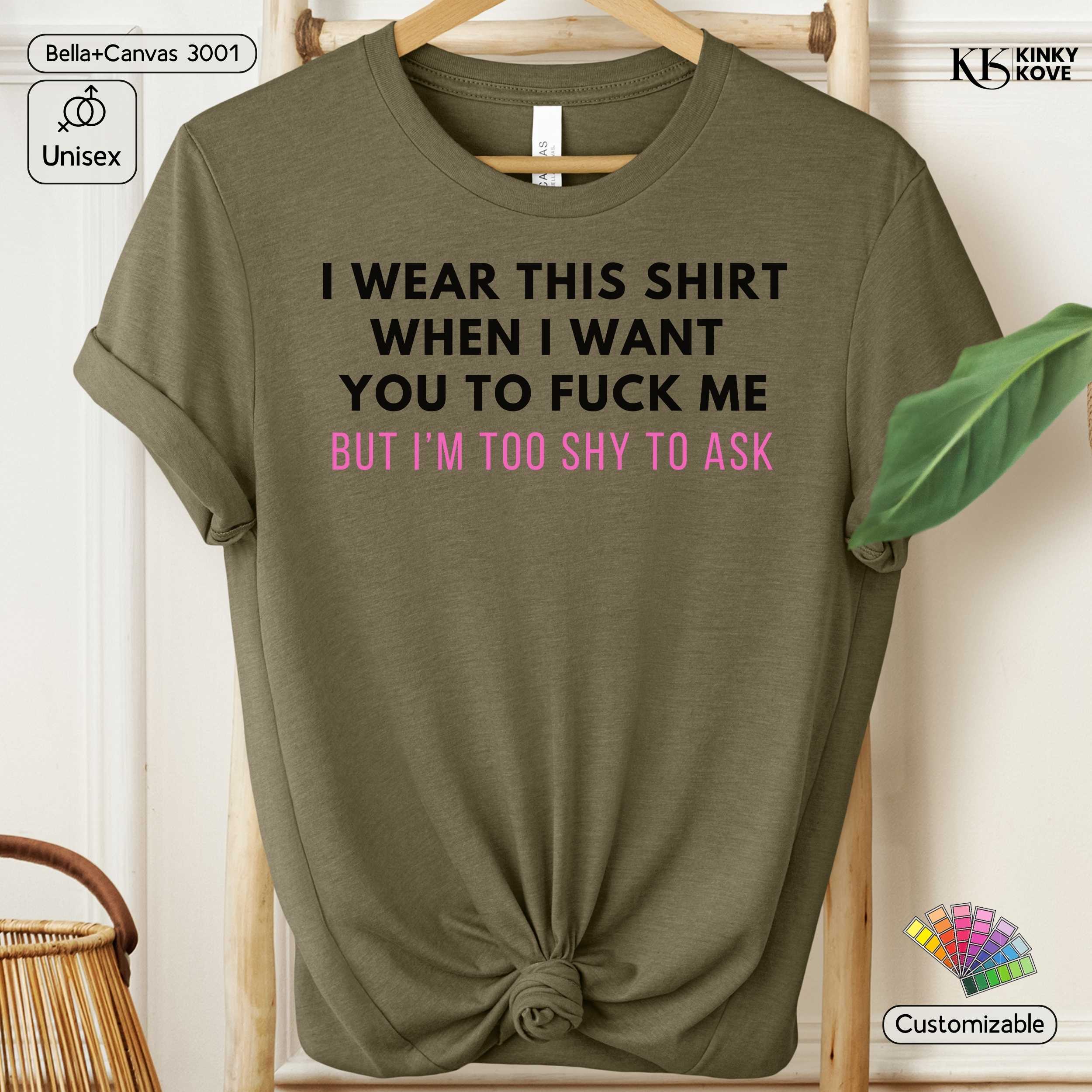 Green t-shirt with a humorous text design on a hanger against a neutral background.