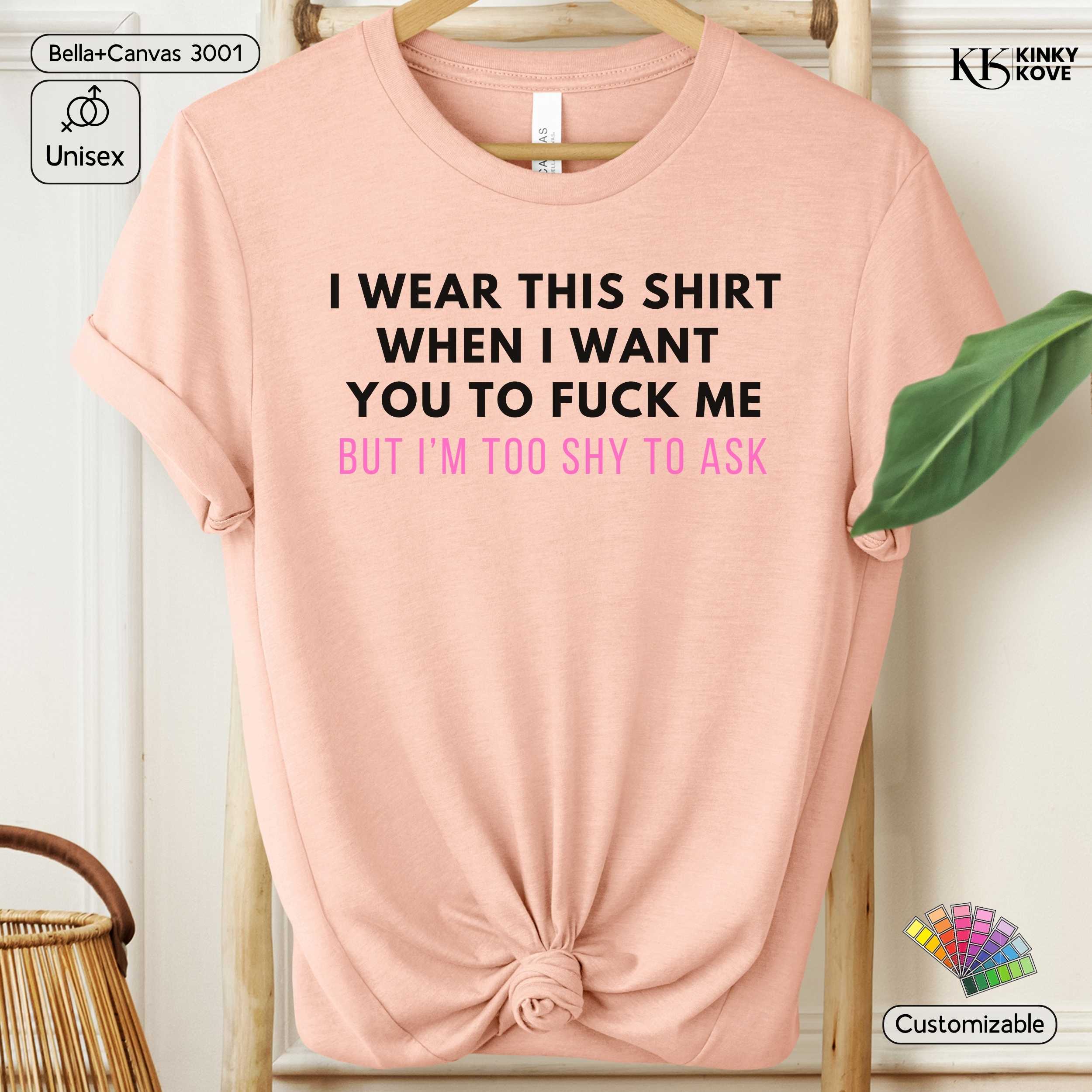 Pink t-shirt with text on a hanger against a white background