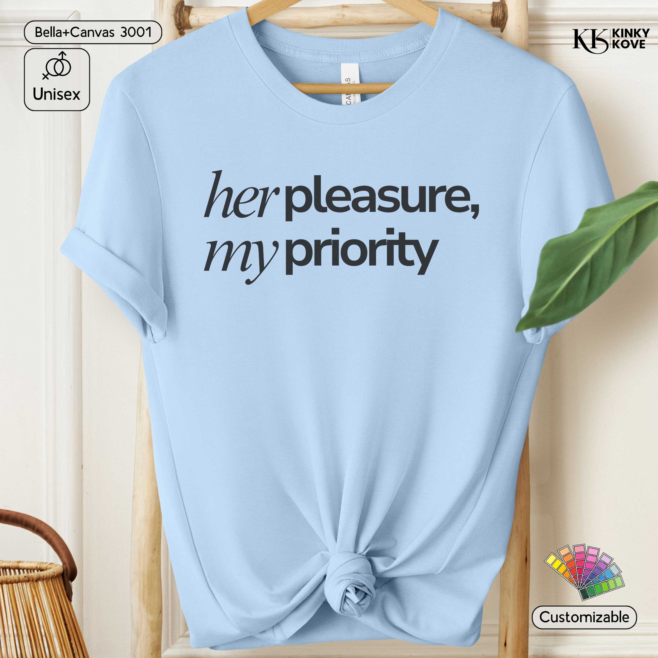 Light blue t-shirt with 'her pleasure, my priority' text on a wooden hanger.