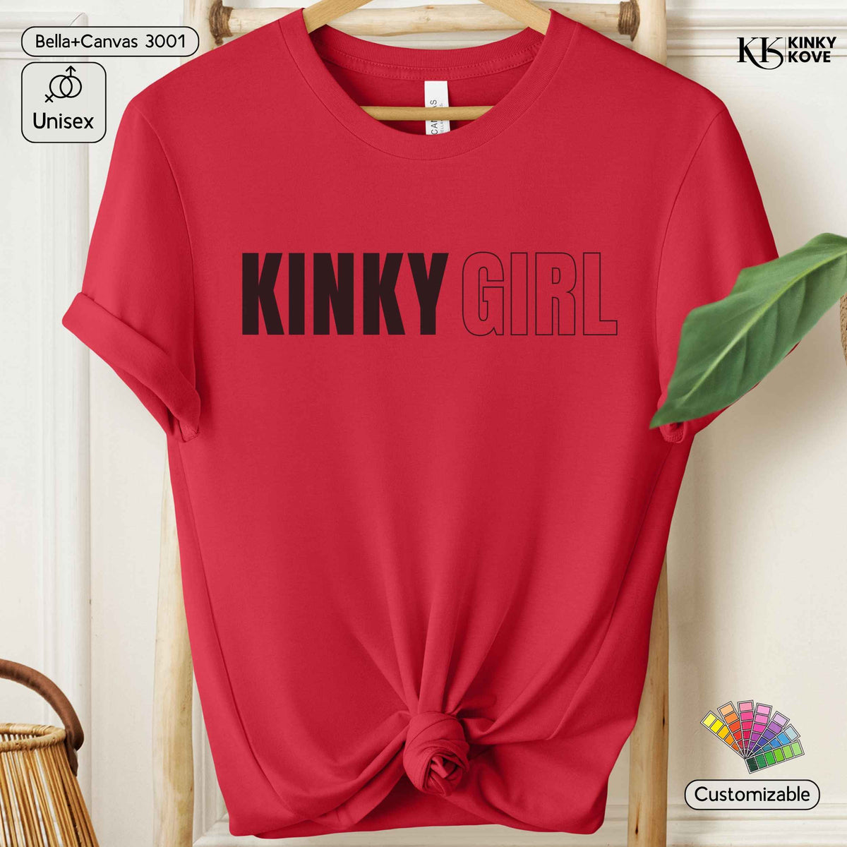 A red short-sleeve t-shirt on a wooden hanger, styled with a knot at the bottom hem. The shirt features the text 'KINKY GIRL' printed across the chest, with 'KINKY' in solid black and 'GIRL' outlined in black.
