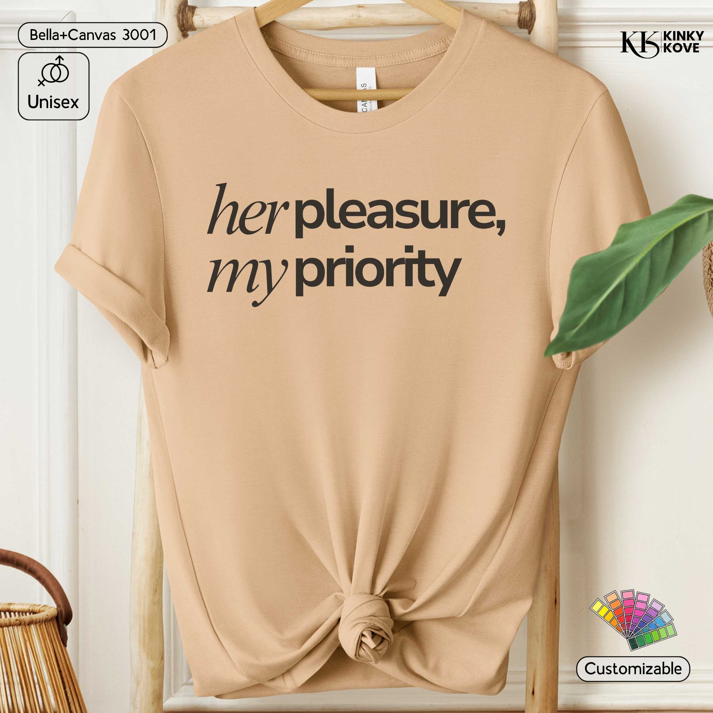 Beige t-shirt with 'her pleasure, my priority' text on a hanger.