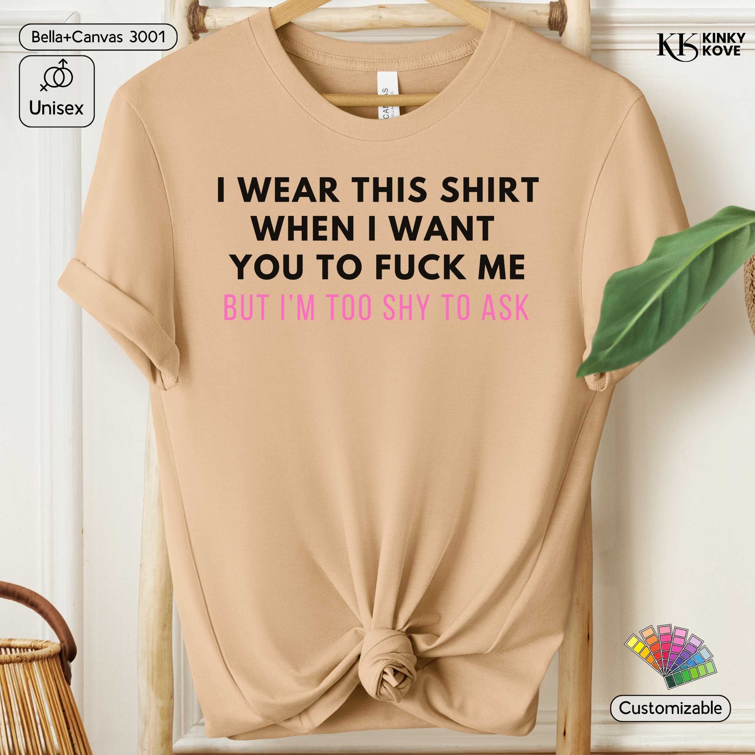 Beige t-shirt with text on a hanger against a white background
