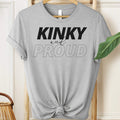 Gray t-shirt with 'Kinky and Proud' text on a hanger.