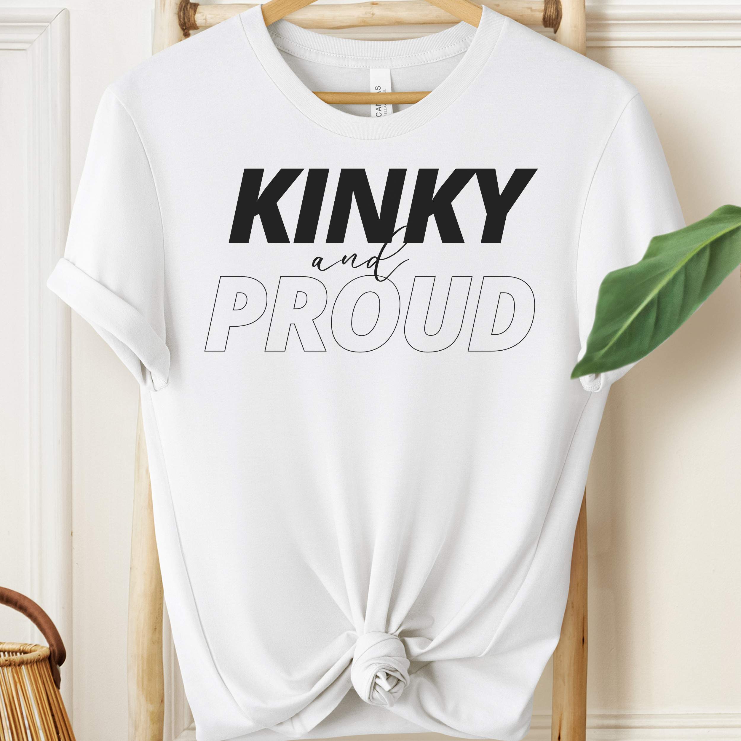 White t-shirt with 'KINKY and PROUD' text on a hanger.