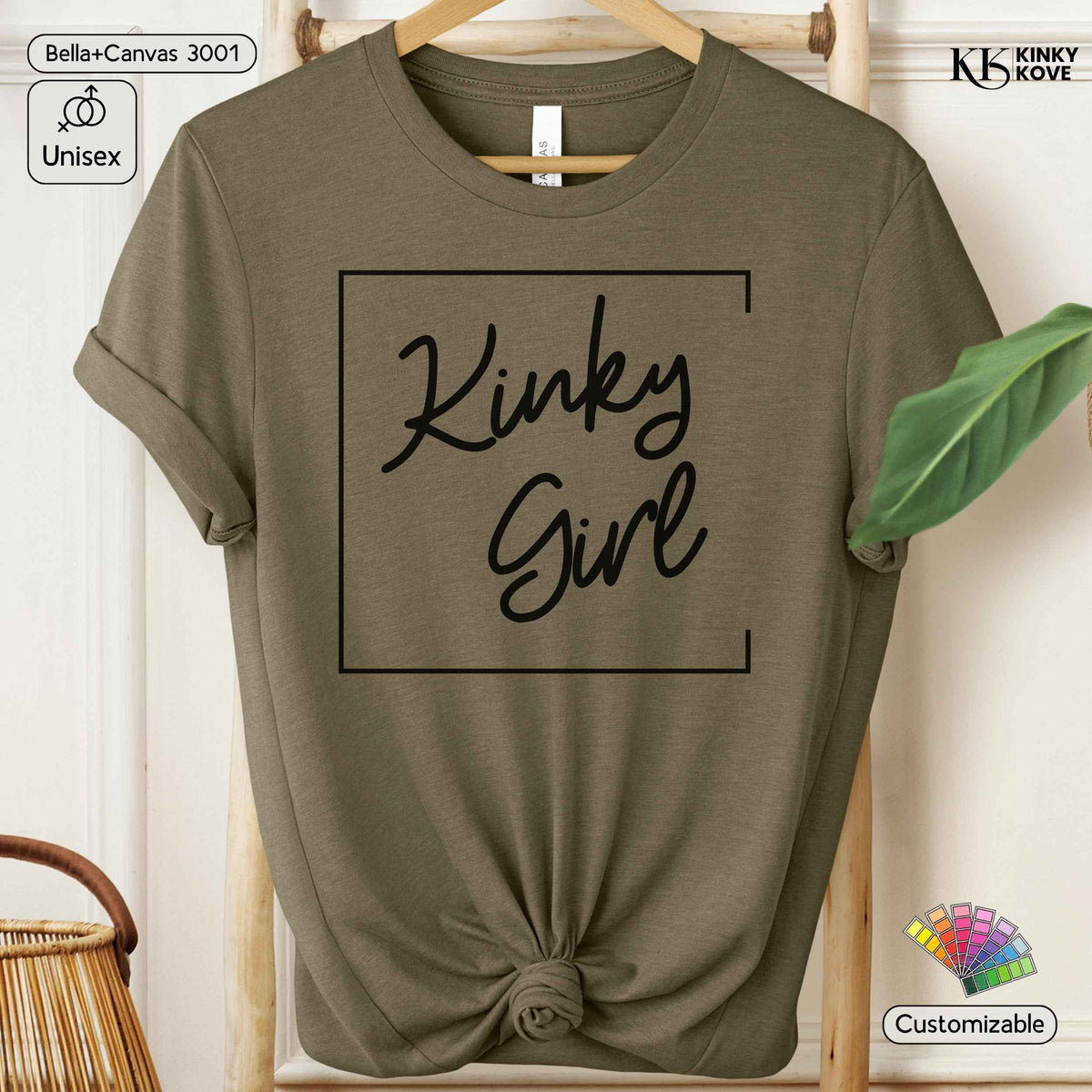 An olive green short-sleeve t-shirt with a black graphic reading 'Kinky Girl' inside a rectangular border, styled on a wooden hanger with a knotted hem. The image includes 'Bella+Canvas 3001' and 'Kinky Kove' text overlays, a 'Unisex' badge, and a 'Customizable' badge.