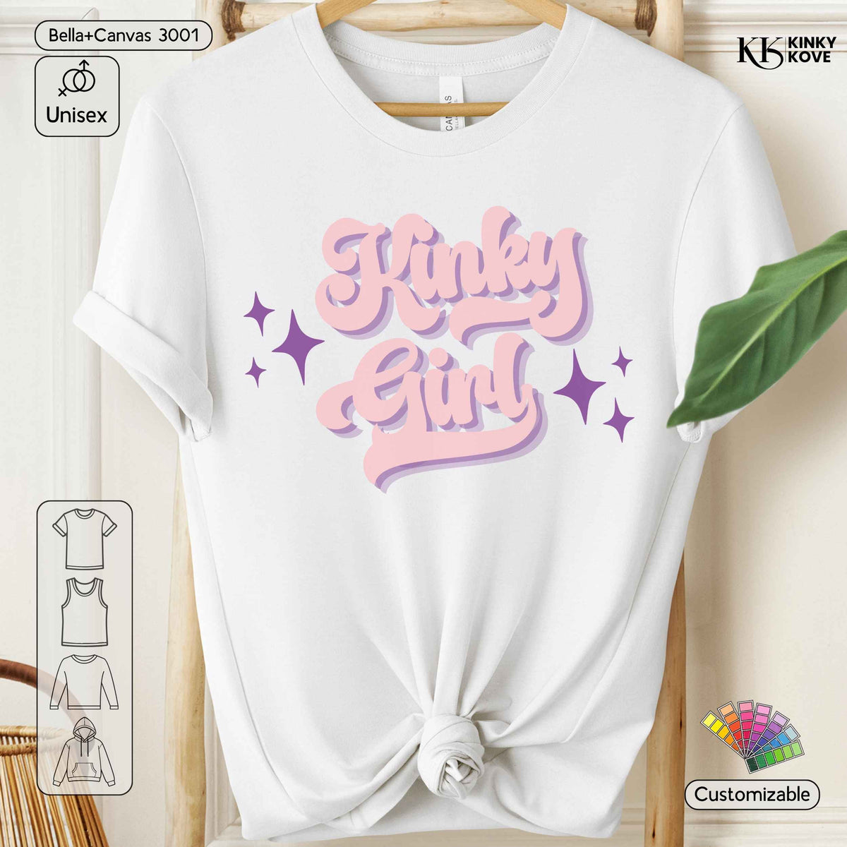 White short-sleeve t-shirt with a knotted hem, featuring a pink and purple retro-style graphic that reads 'Kinky Girl' with star accents. The t-shirt is displayed on a wooden hanger against a light wood-paneled background.