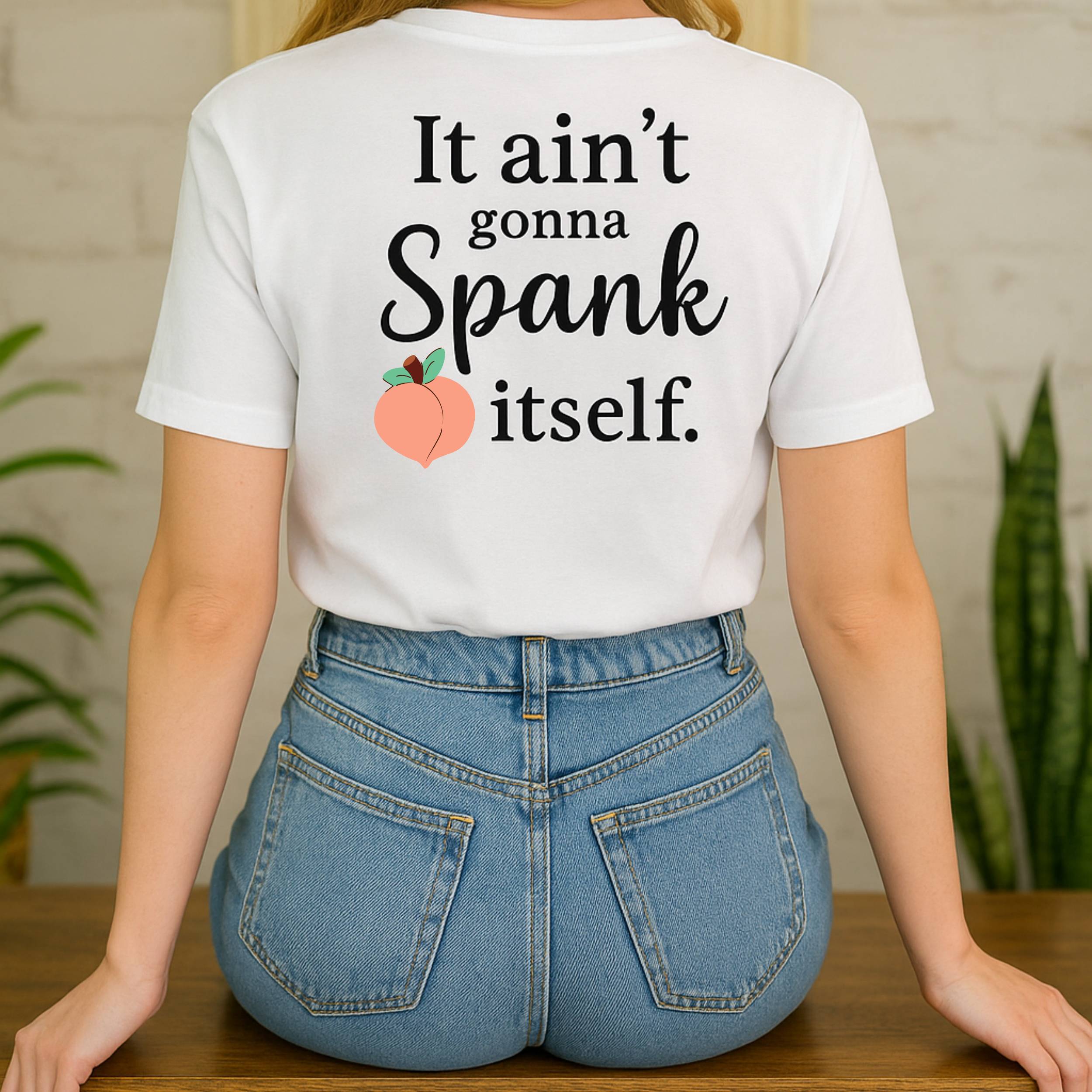 Person wearing a white t-shirt with humorous text and peach graphic, standing in a casual setting.