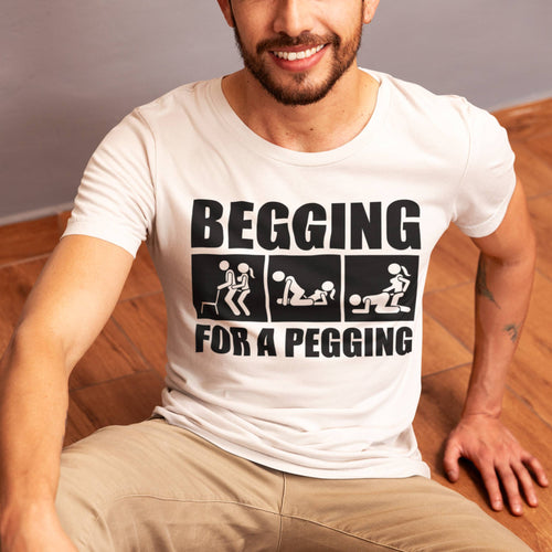 Man wearing a white t-shirt with graphic text design sitting on a wooden floor.