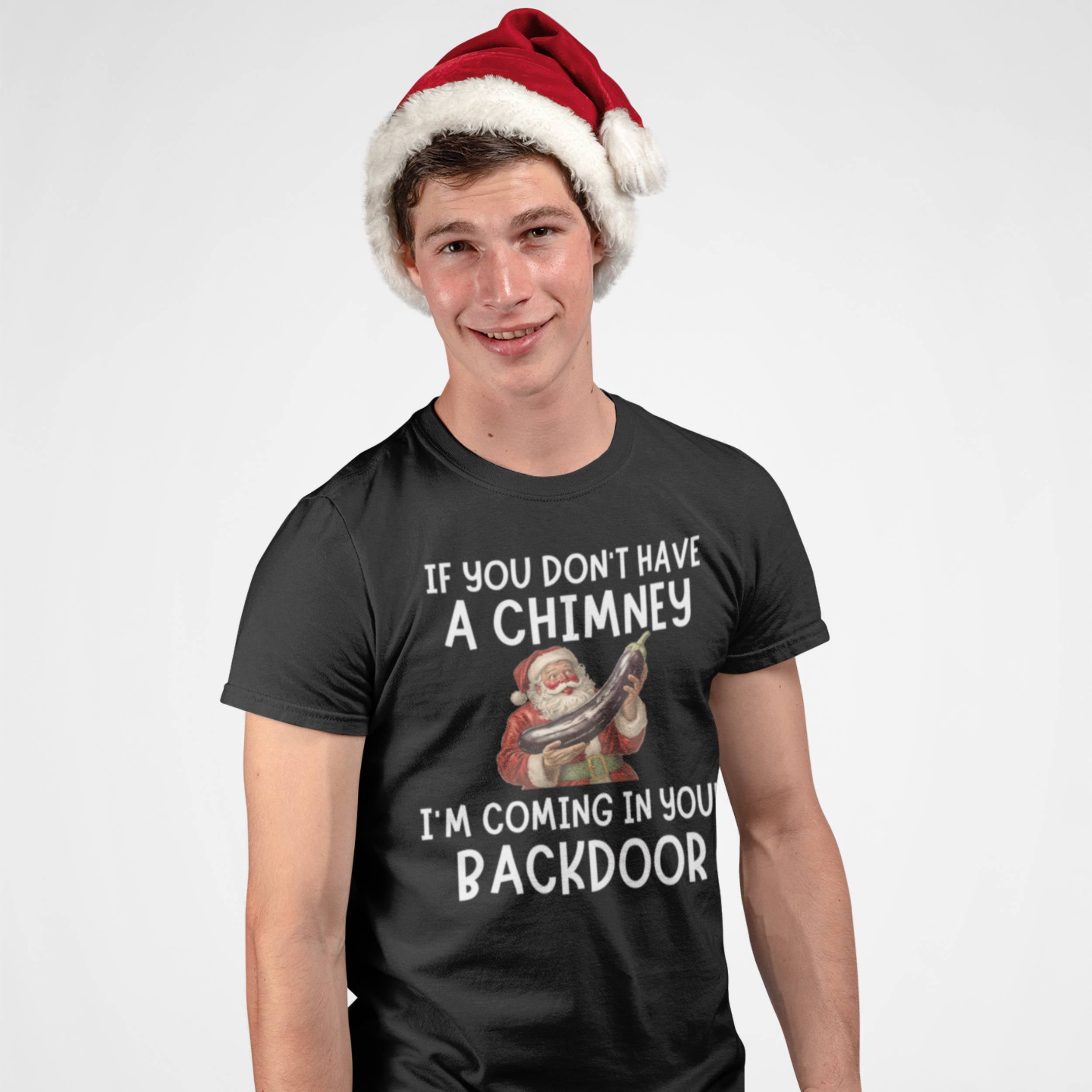 Person wearing a black t-shirt with a Christmas-themed graphic and text, paired with a Santa hat.