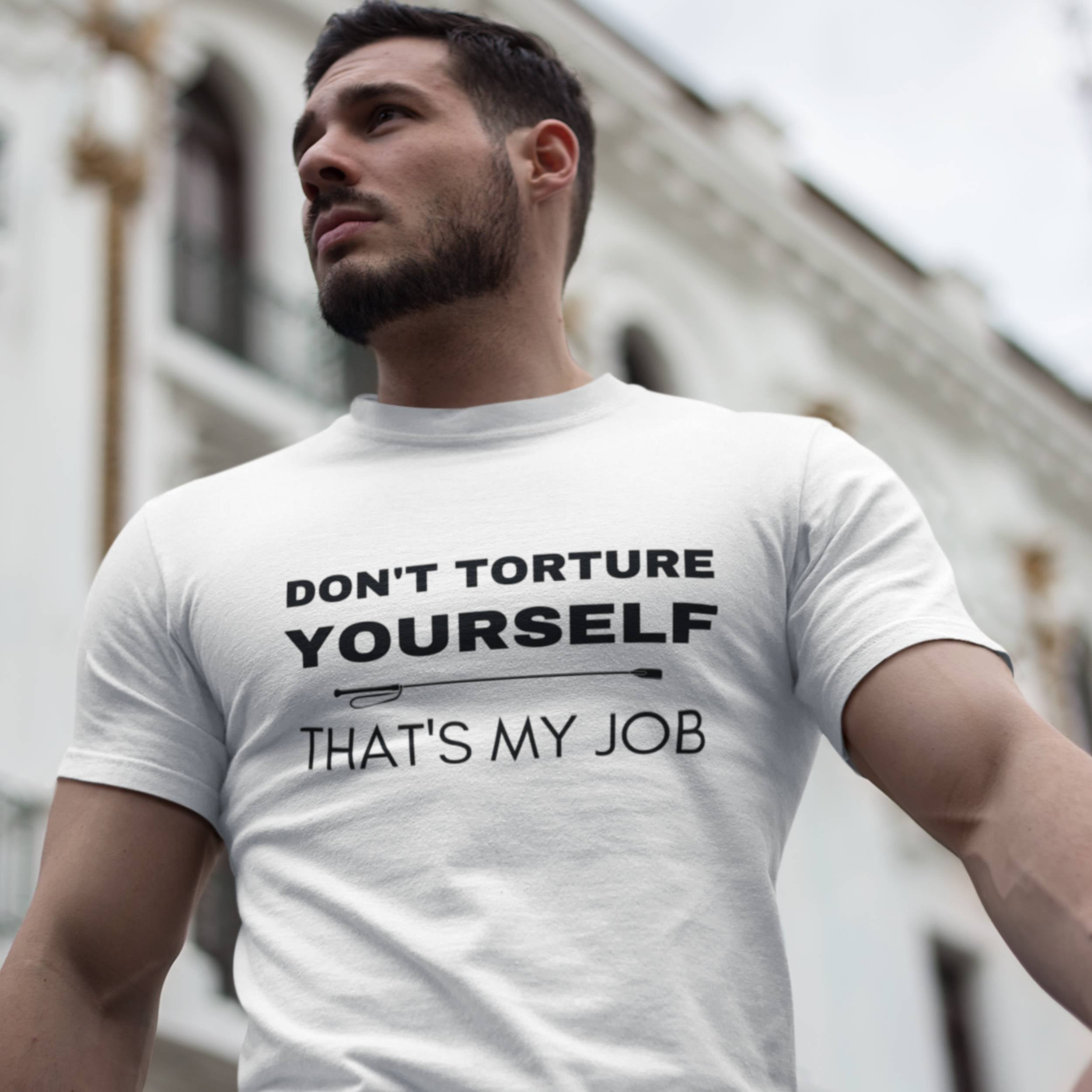 Man wearing a white t-shirt with a motivational quote outdoors.
